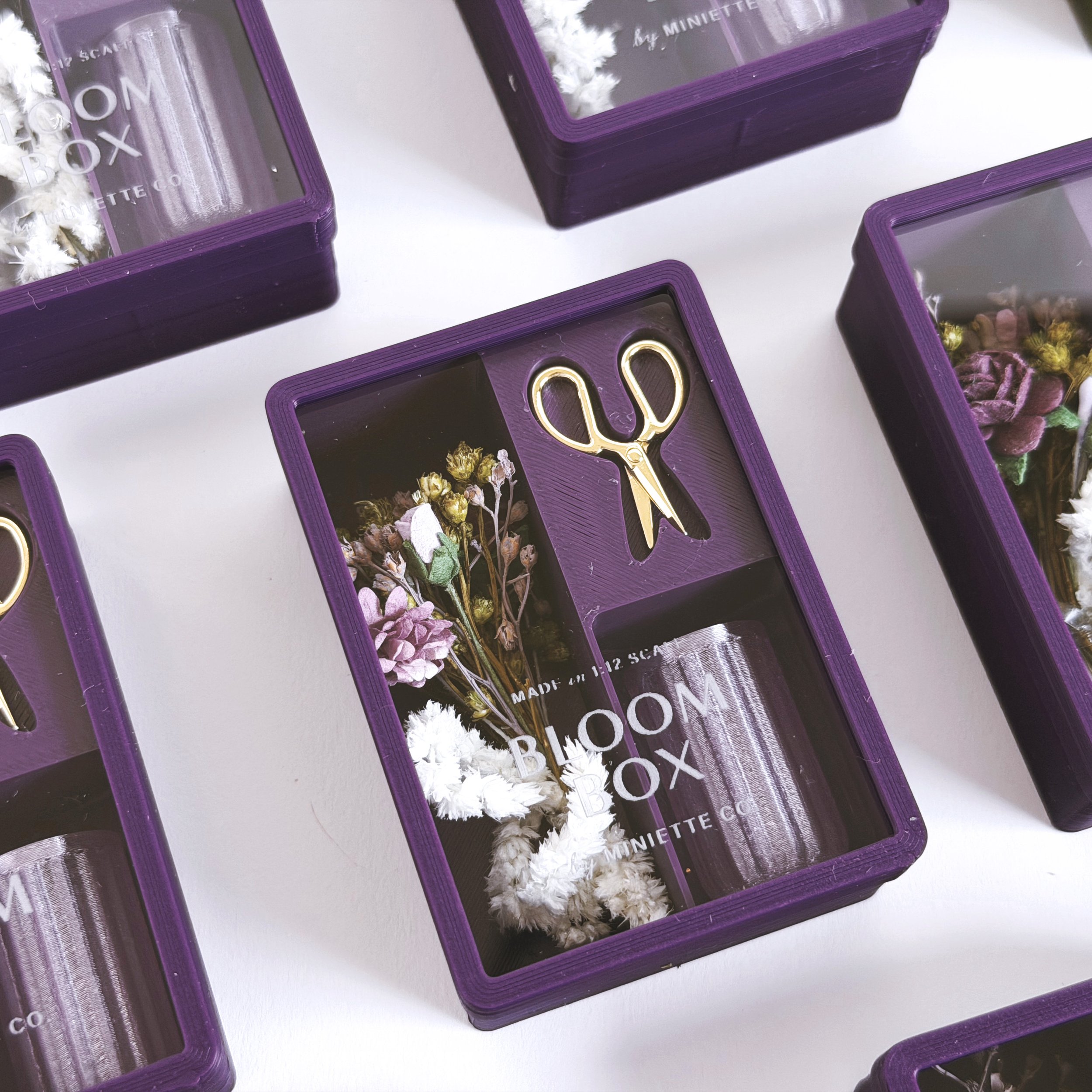 Set of purple Bloom Box miniature floral gift sets displayed together in clear packaging