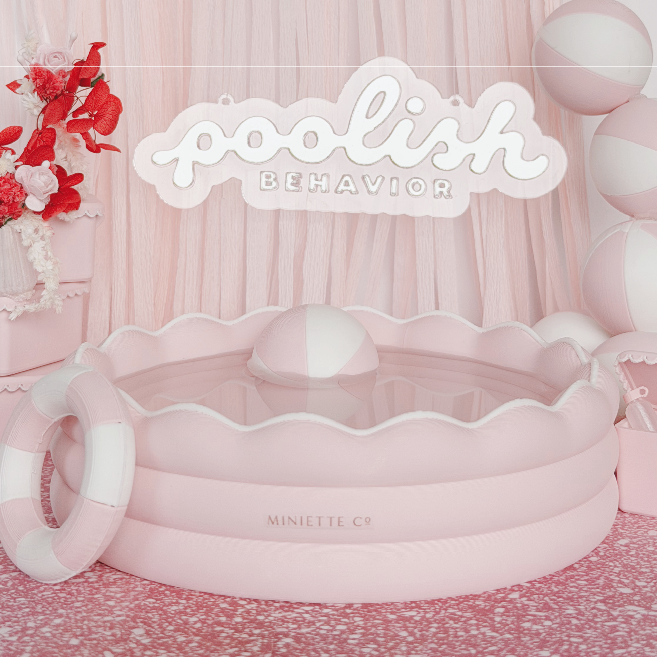 Miniature kiddie pool styled in a dollhouse backyard with towels, cooler, and summer accessories.