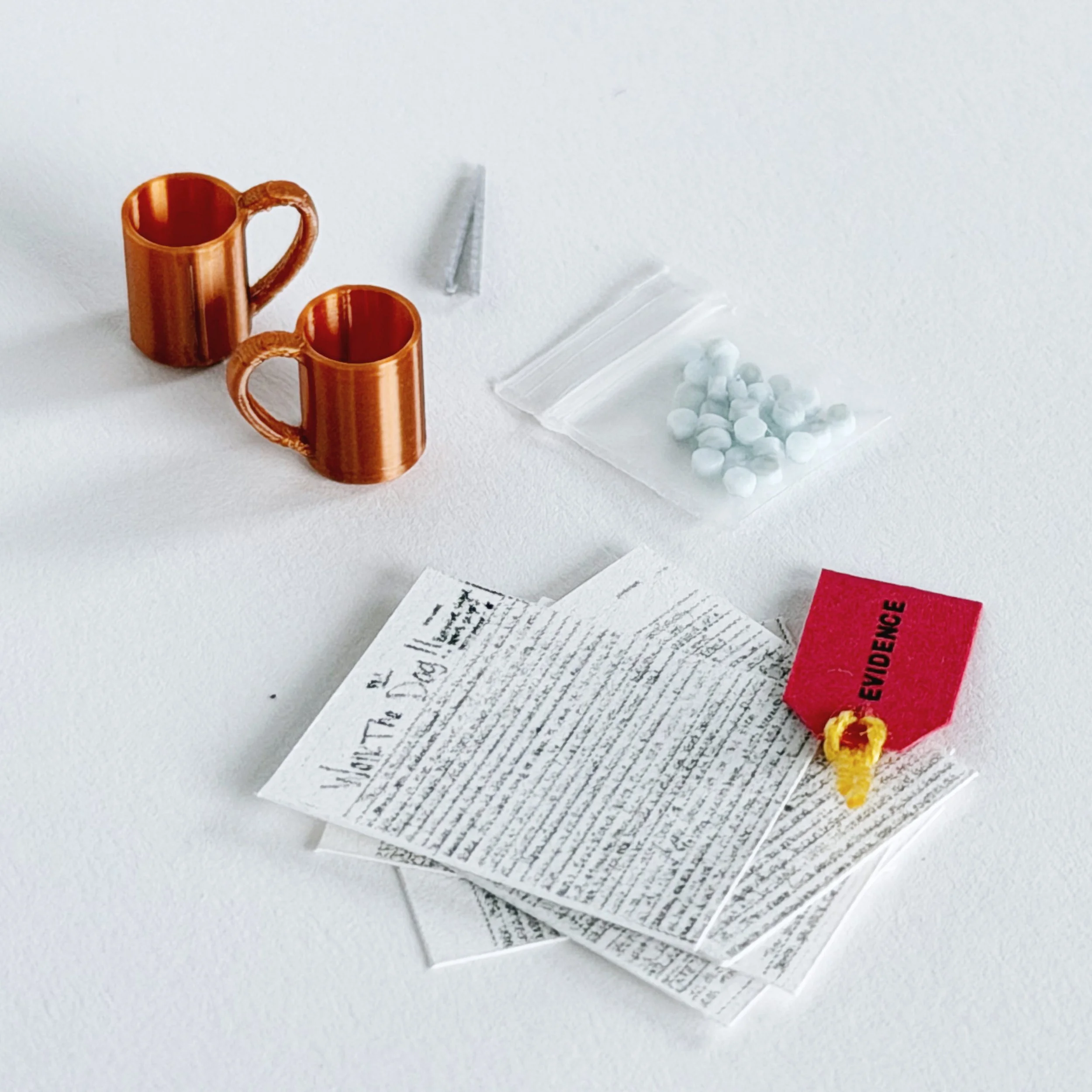 1:12 scale miniature evidence box inside clear acrylic display case with tiny accessories including mugs, letter, pills, and evidence tag