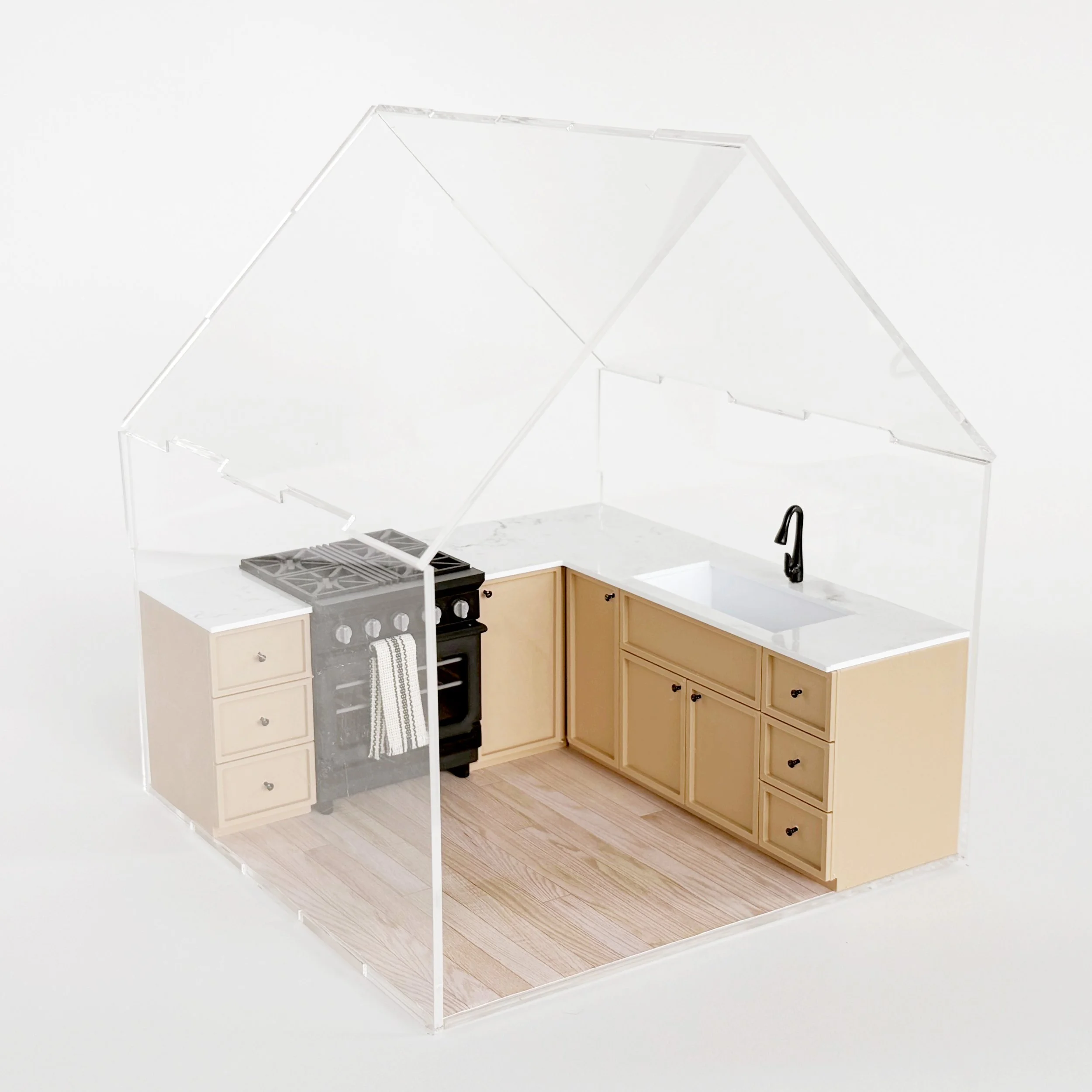 Modern miniature kitchen setup featuring natural cabinets and oven, styled inside a clear acrylic dollhouse display. (Copy)