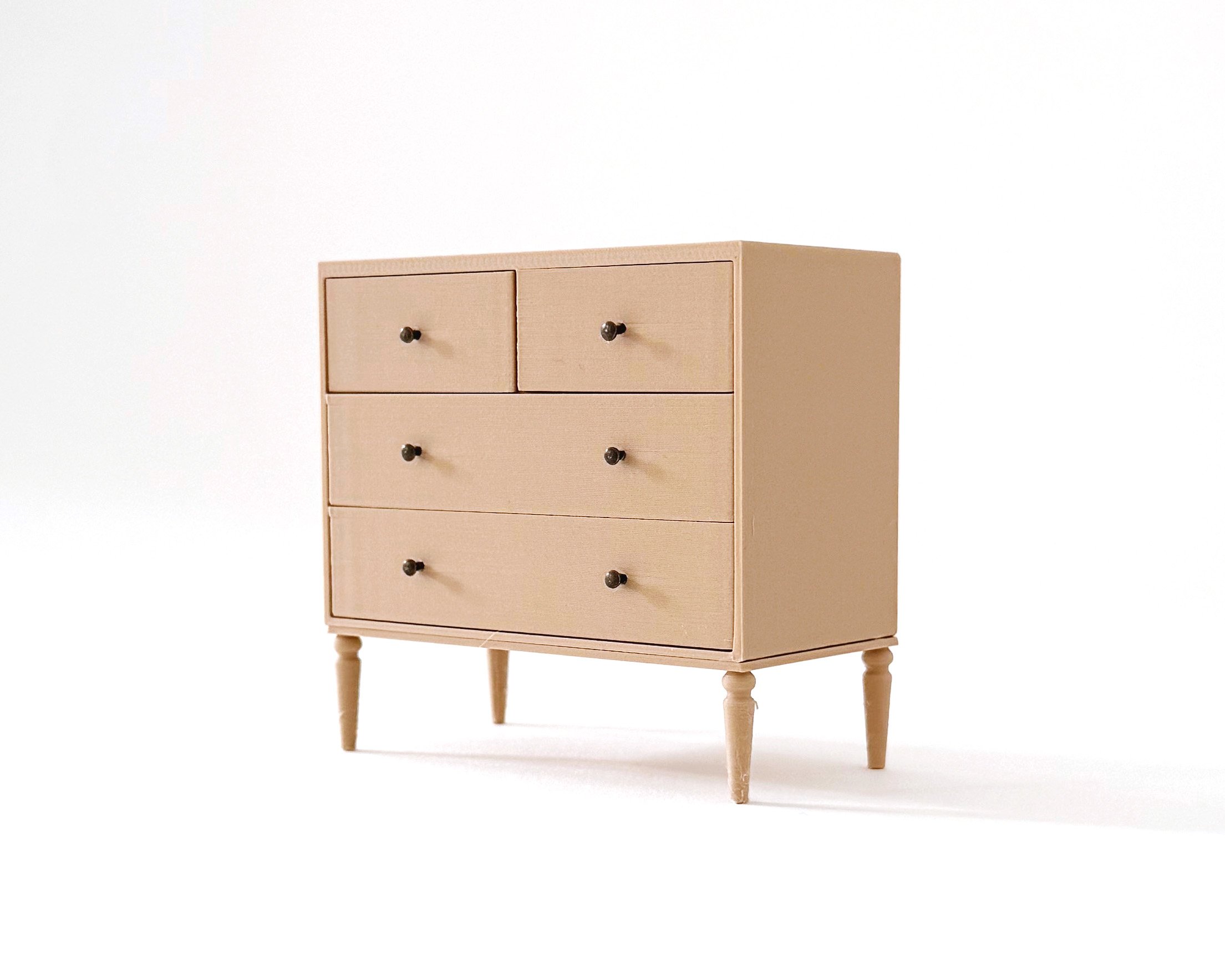 Miniature dollhouse dresser with 4 drawers in natural wood color. Elegant, modern storage featuring intricate tapered legs. Functioning drawers.