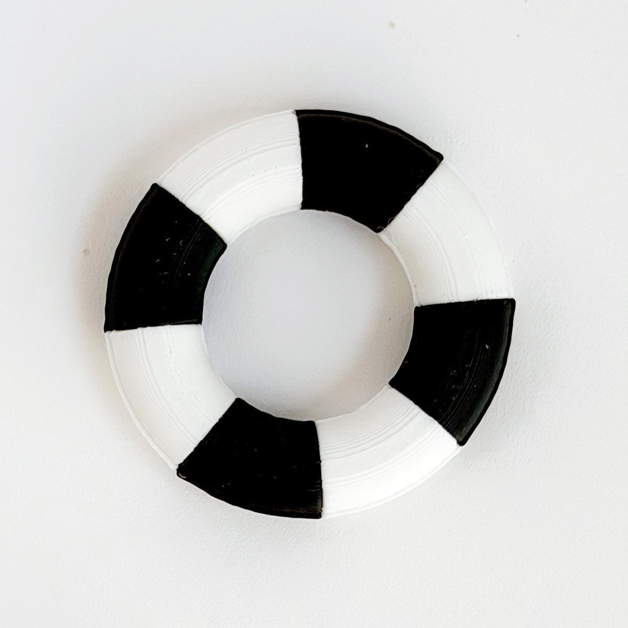 1:12 scale miniature pool float in black and white stripe styled for modern dollhouse outdoor setting