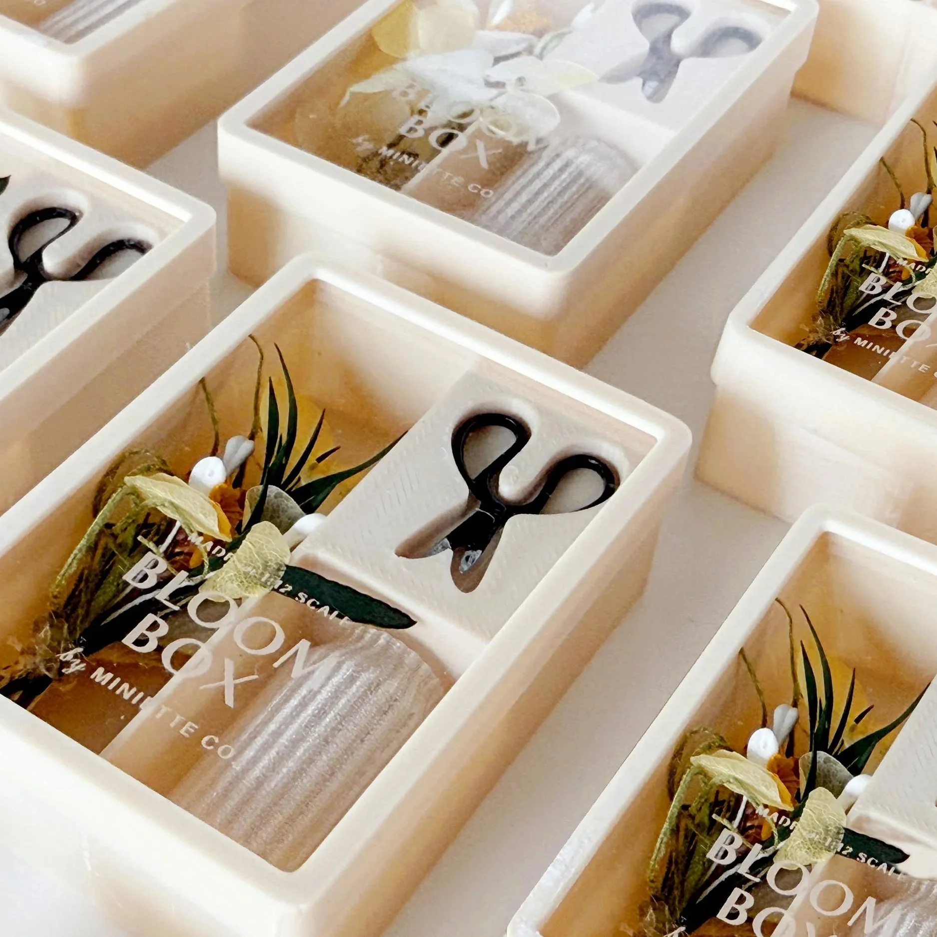 Spring Yellow Bloom Box miniature floral arrangement with soft yellow flowers and light greenery in a slightly transparent vase