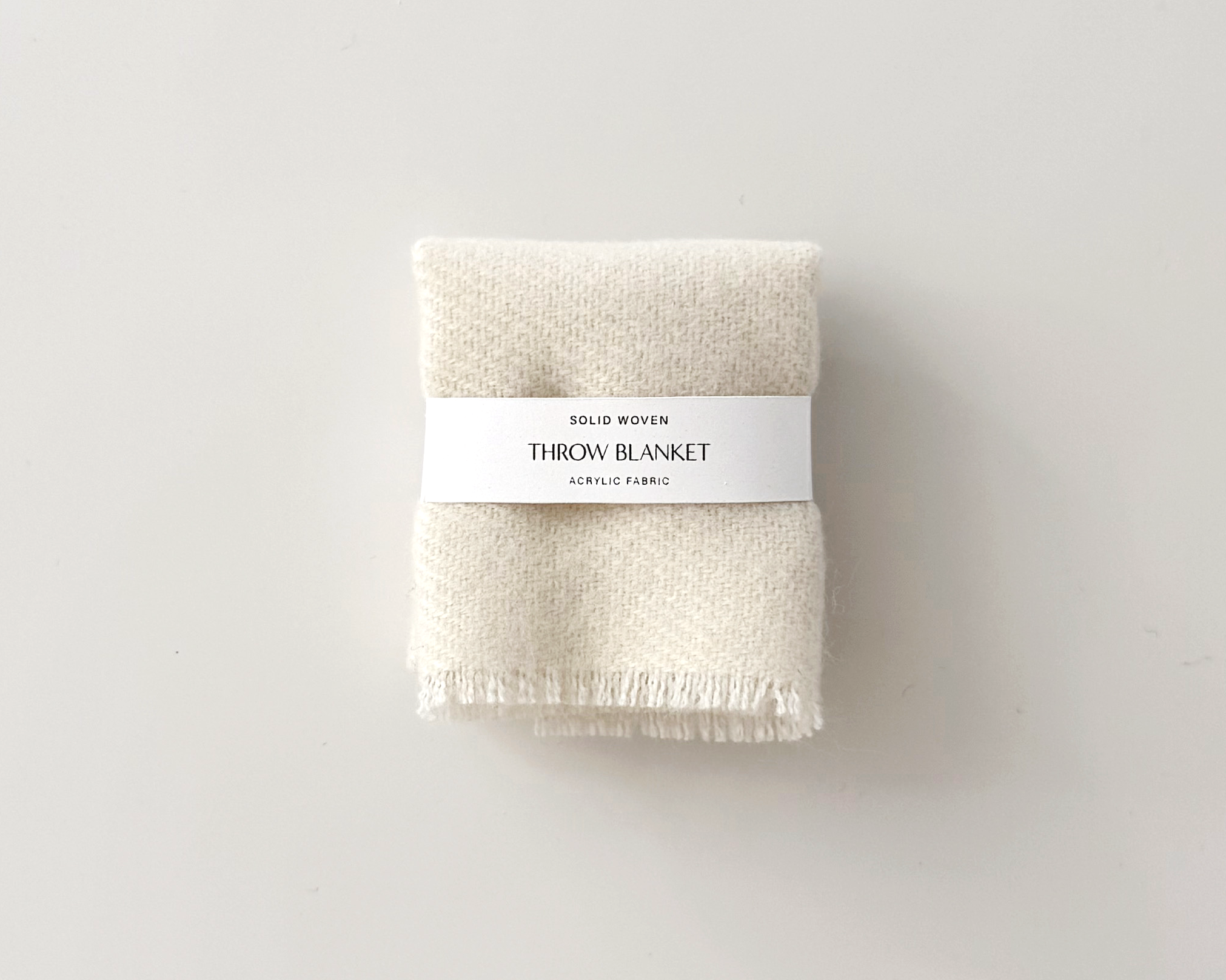 Handmade dollhouse blanket in 1:12 scale. Soft woven acrylic throw with fringed edge, available in ivory