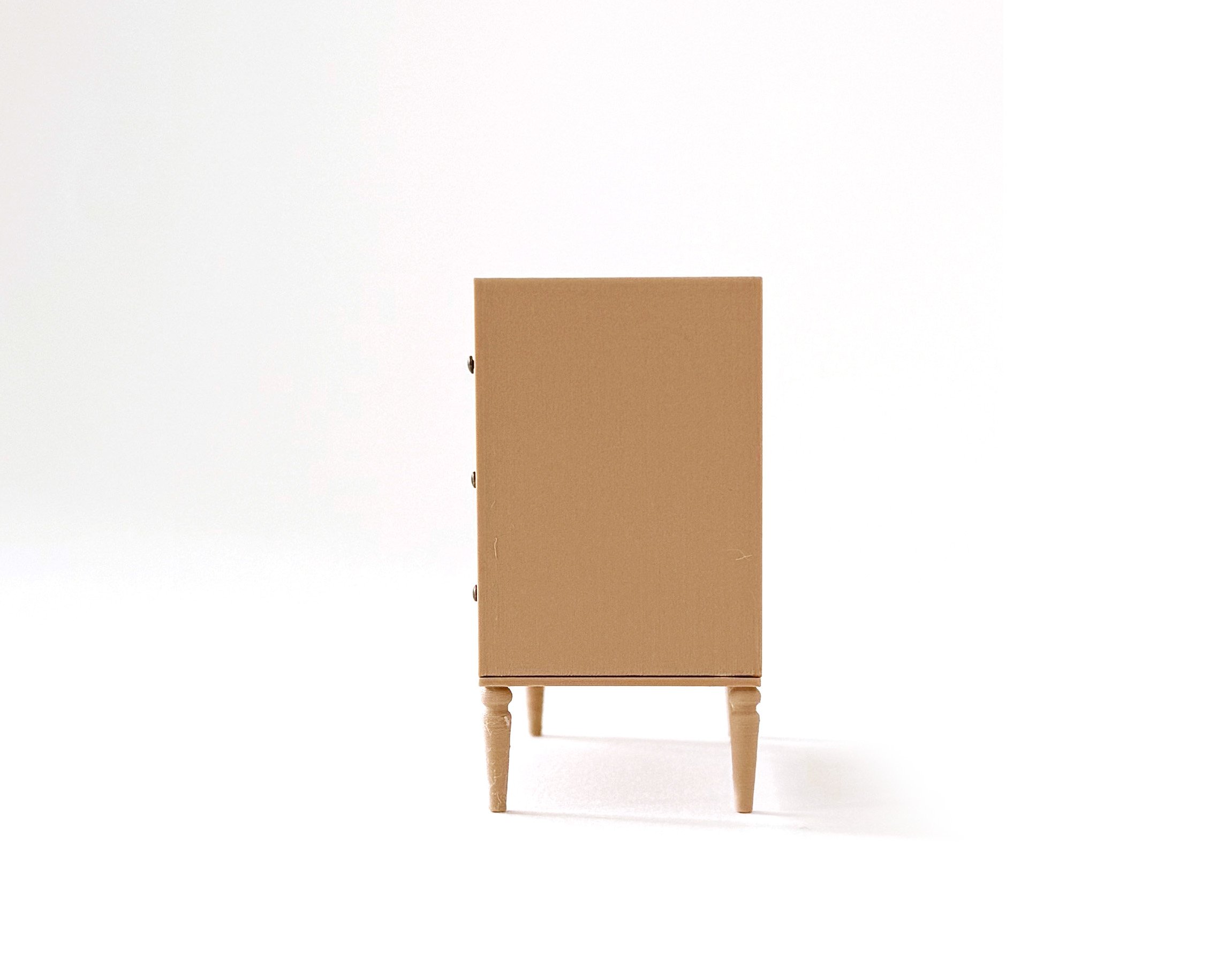 Miniature dollhouse dresser with 4 drawers in natural wood color. Elegant, modern storage featuring intricate tapered legs. Functioning drawers.