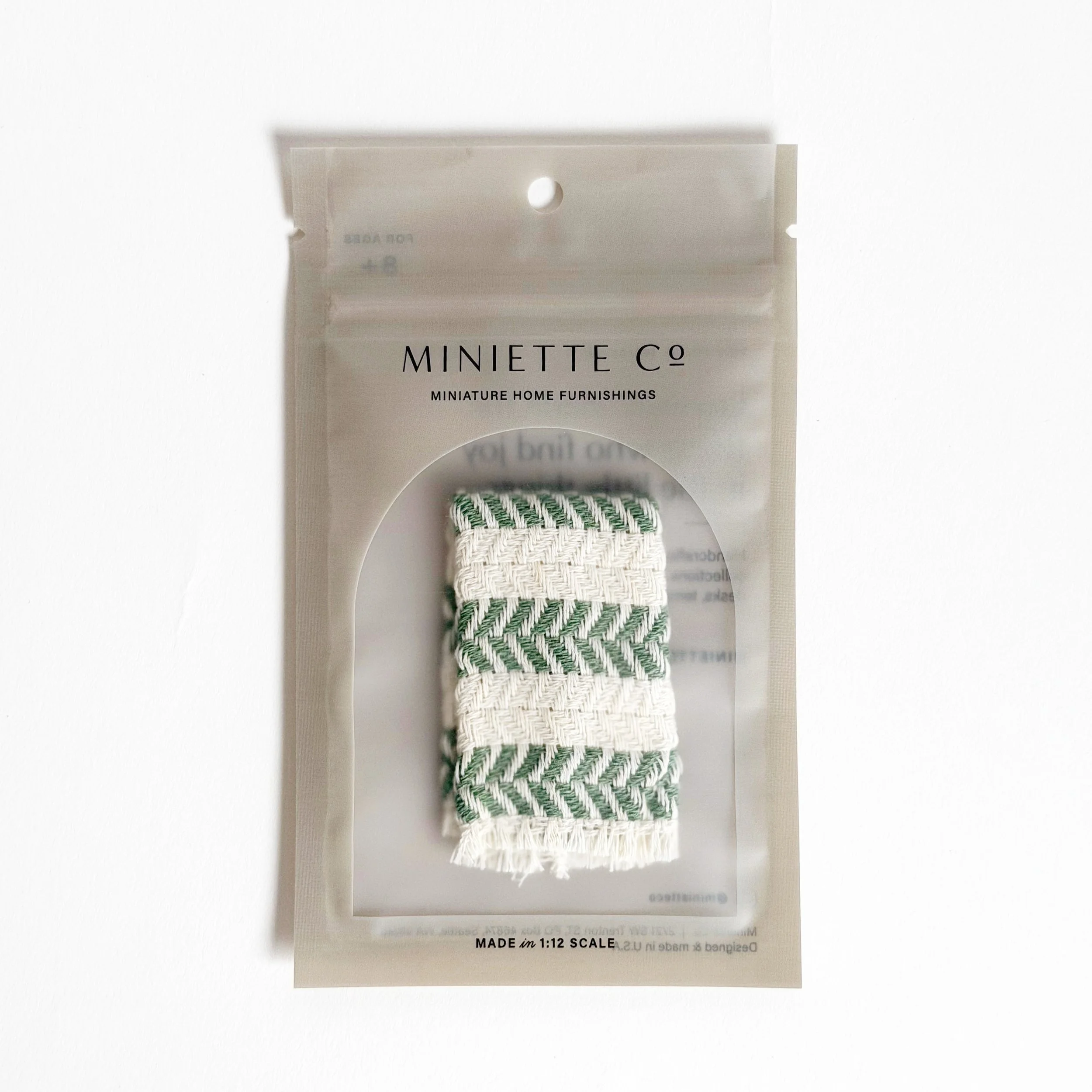 Miniature green beach towel styled for poolside or patio setup