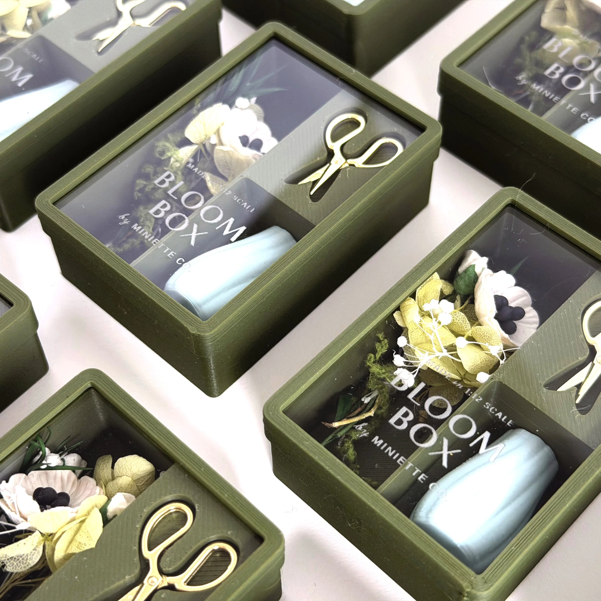 Set of green Bloom Box miniature floral gift sets displayed together in clear packaging