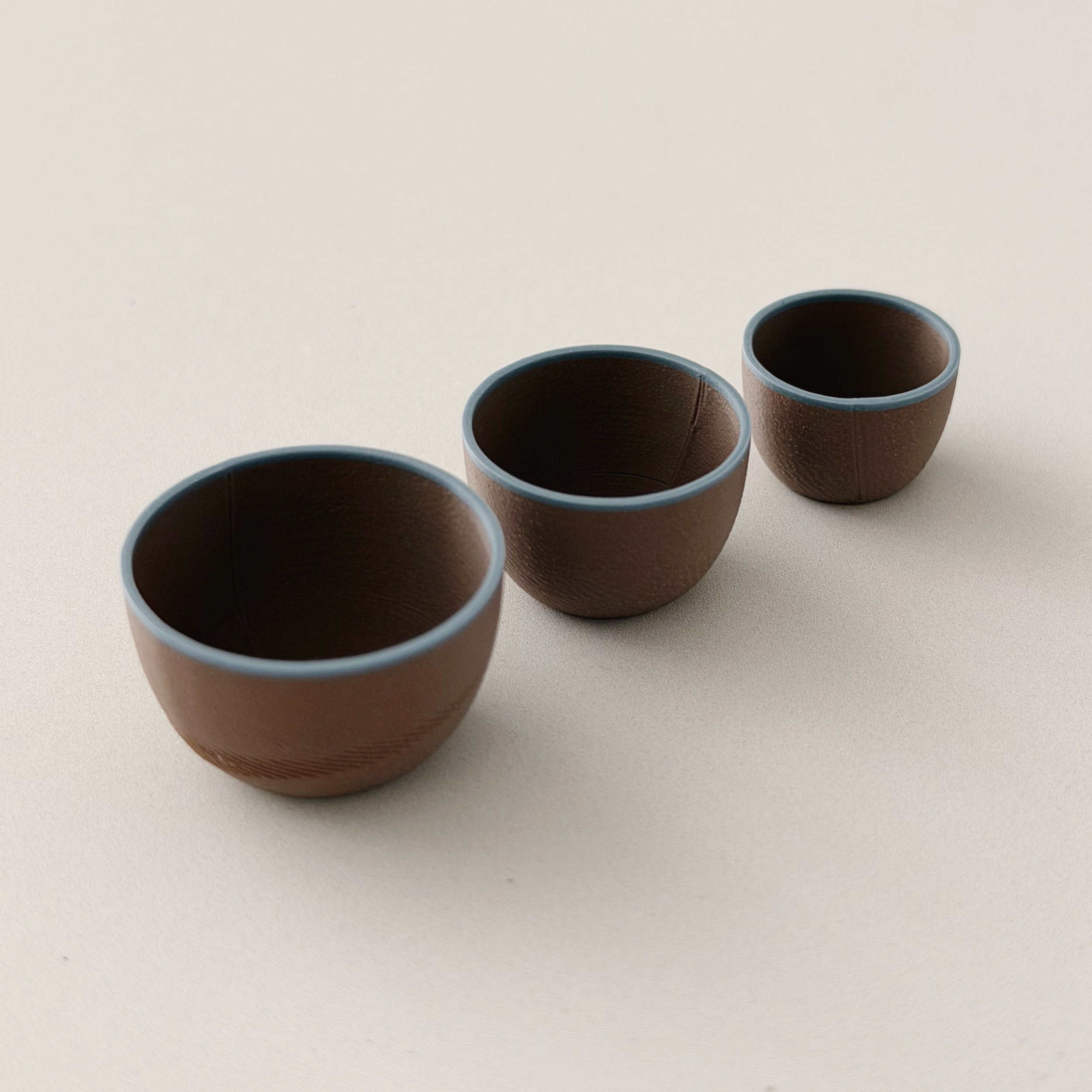 Miniature brown and blue nesting bowls stacked for a dollhouse kitchen
