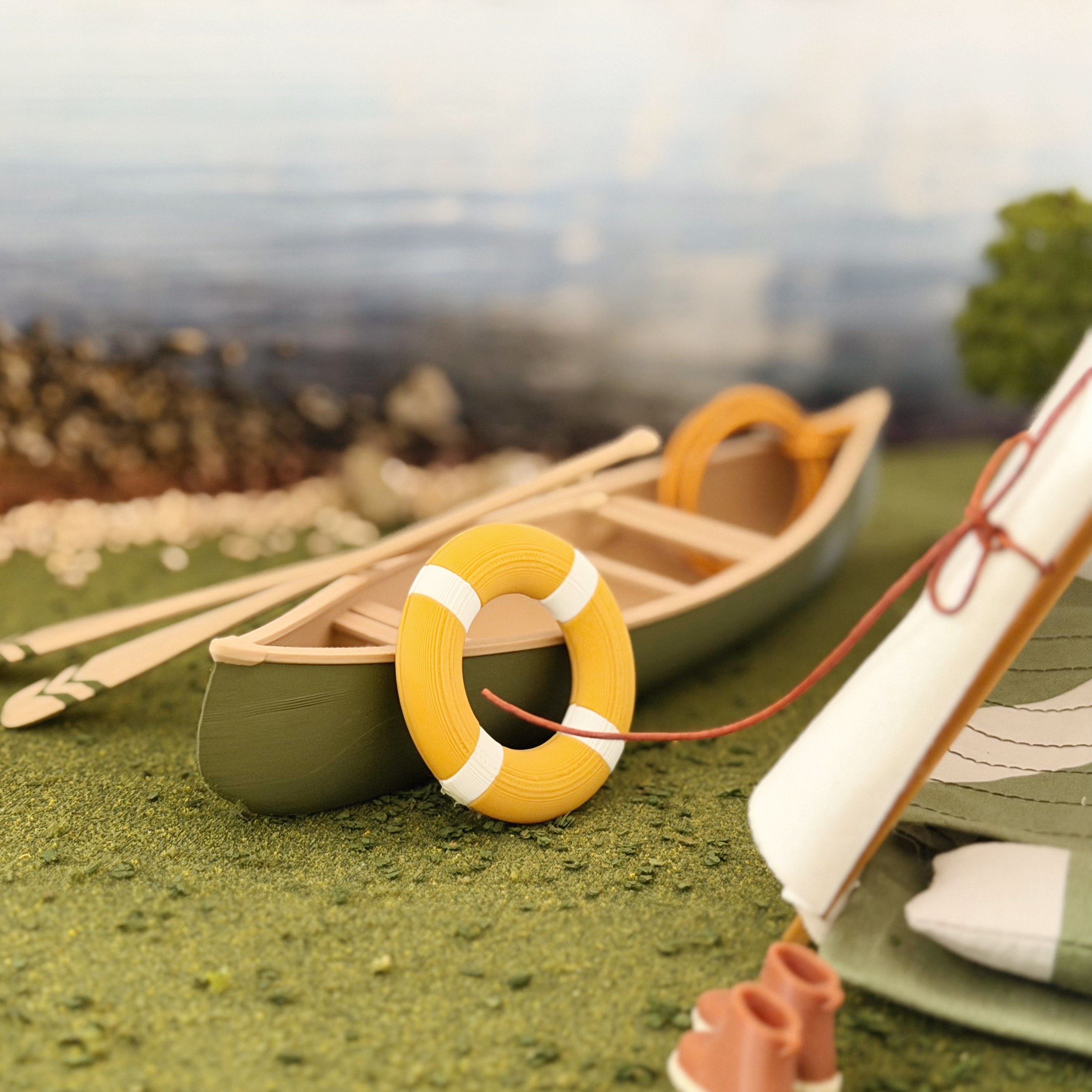 Miniature life ring styled beside a dollhouse canoe.
