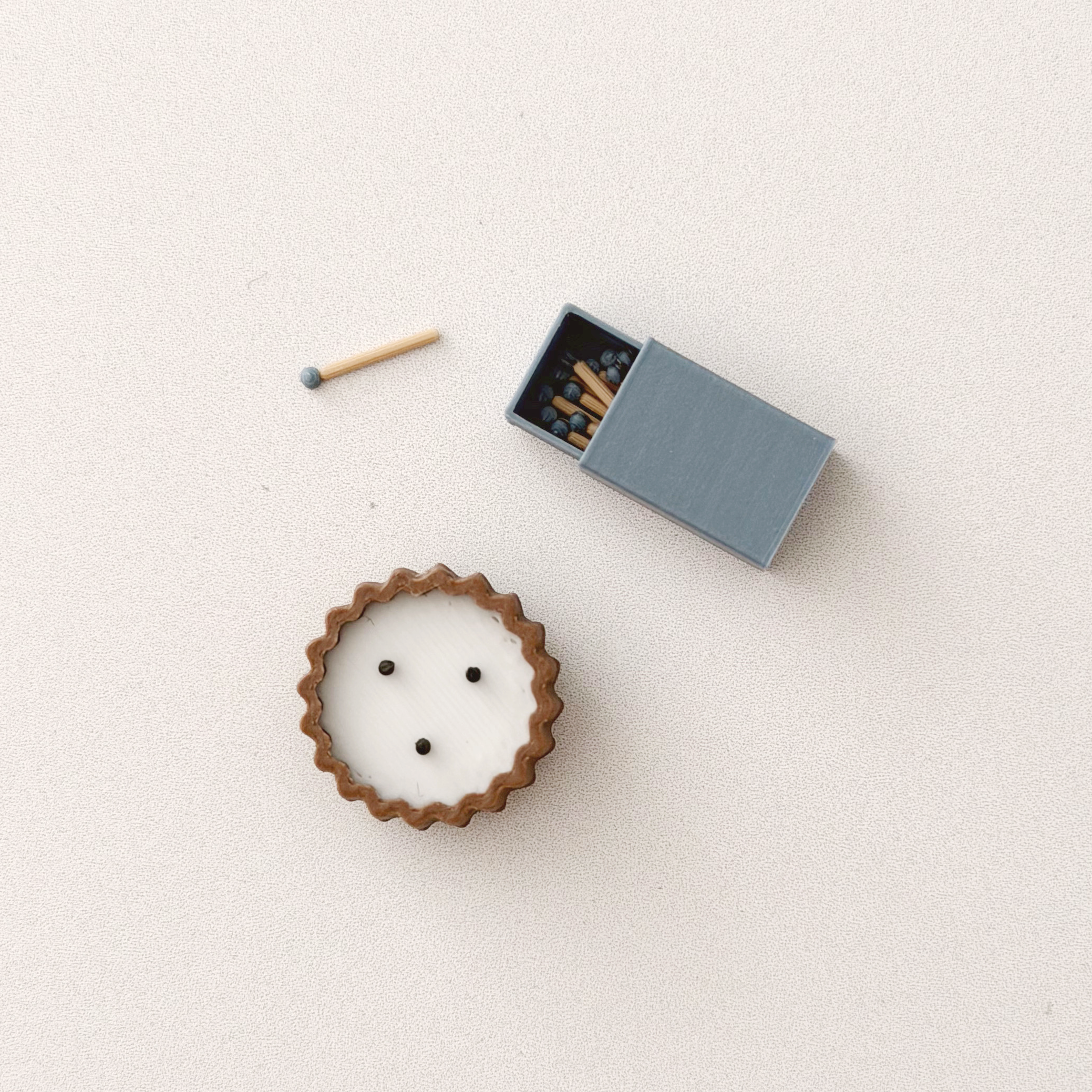 Close-up of a tiny blue matchbox with miniature wooden matches