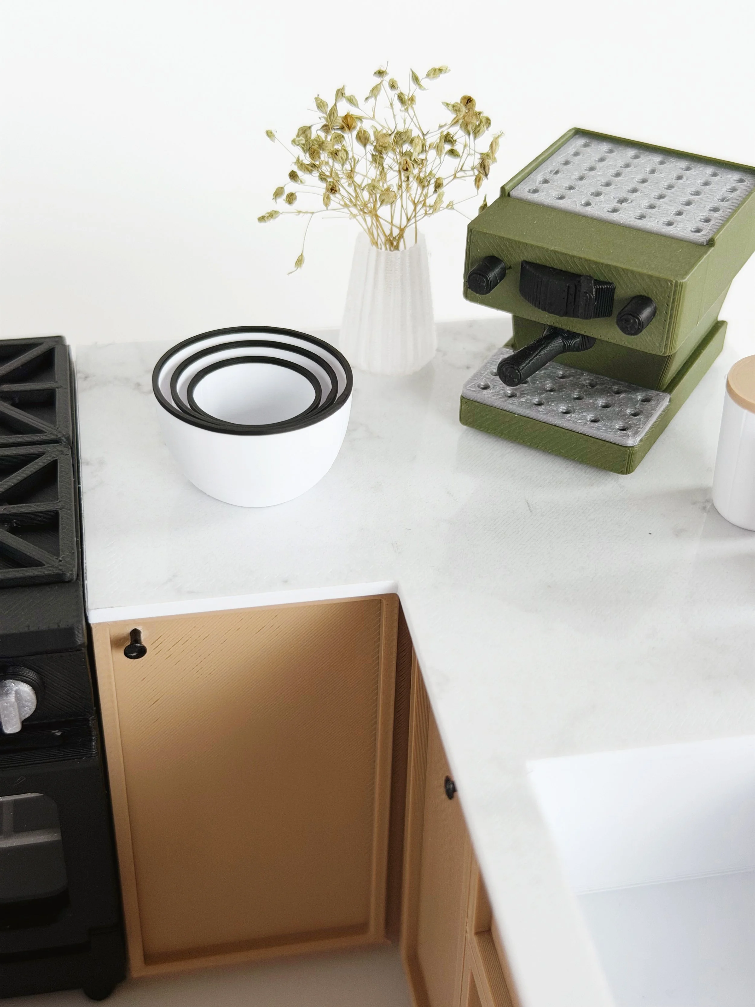 Angled view of white and black 1:12 scale miniature nesting bowls, showing depth and proportions.