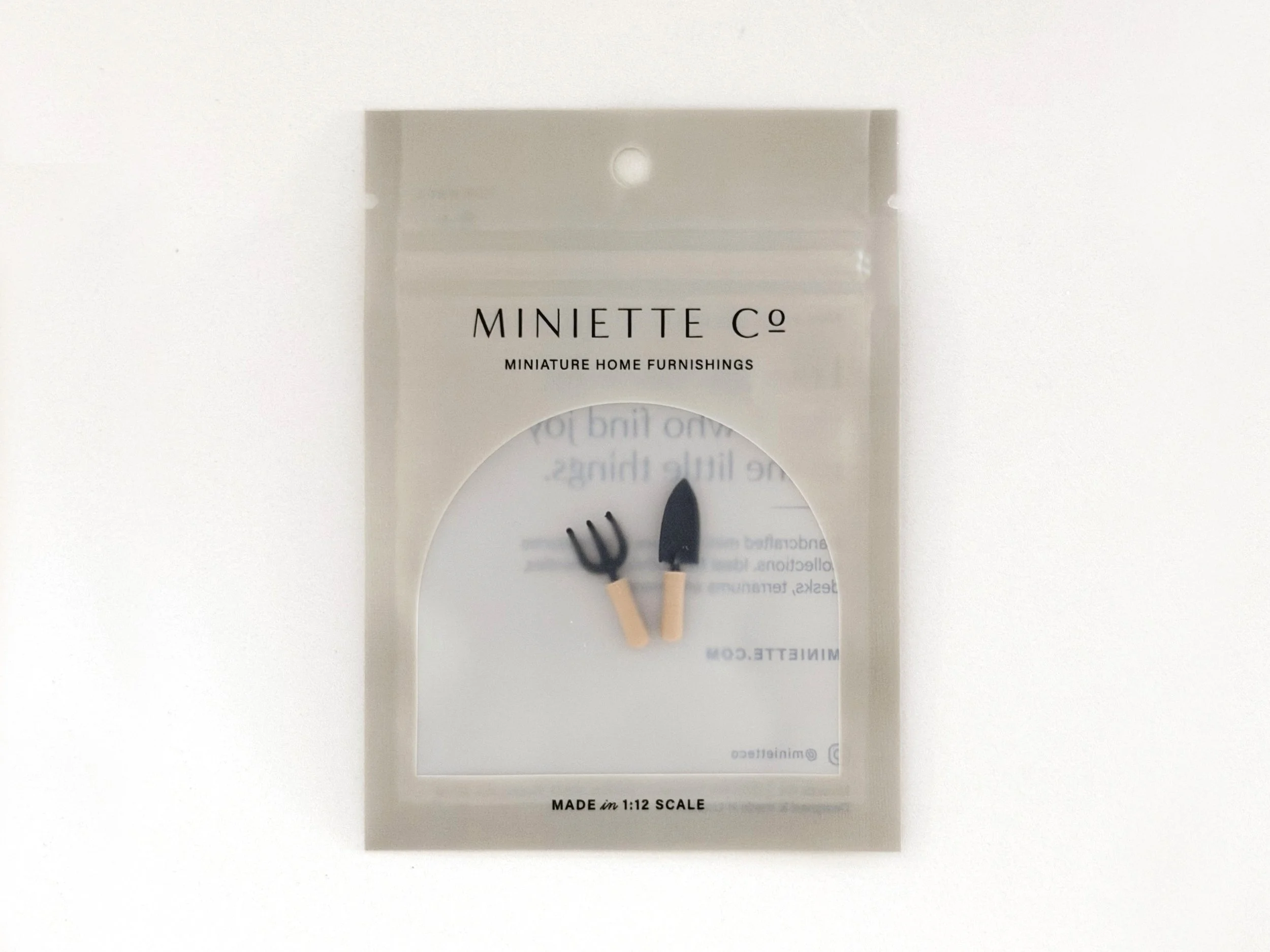 2-piece miniature garden tool set styled in a dollhouse potting shed or backyard scene.