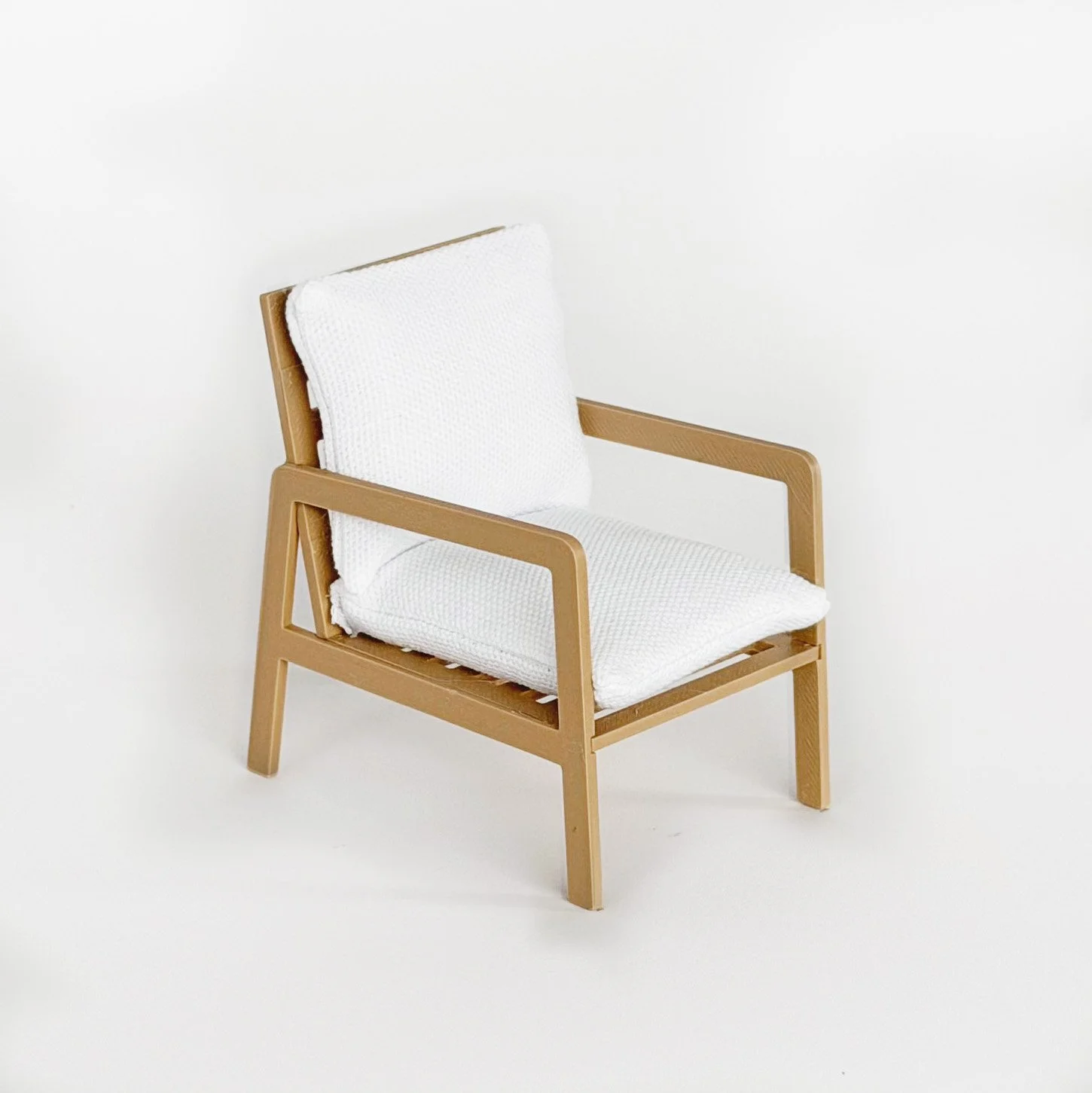 Side view of 1:12 scale modern dollhouse armchair with clean lines and minimalist silhouette