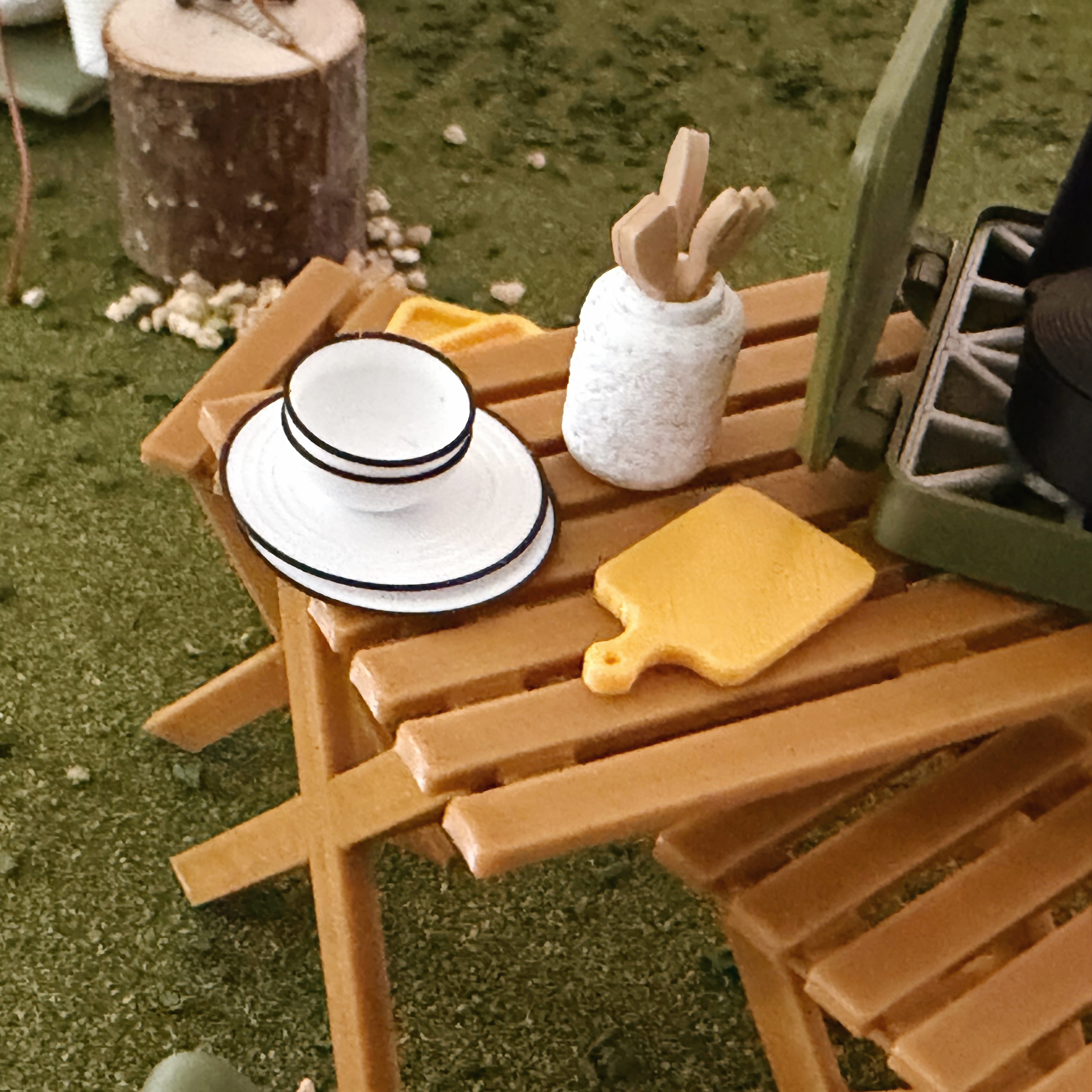 Close-up of miniature white dishes with black rims for dollhouses.