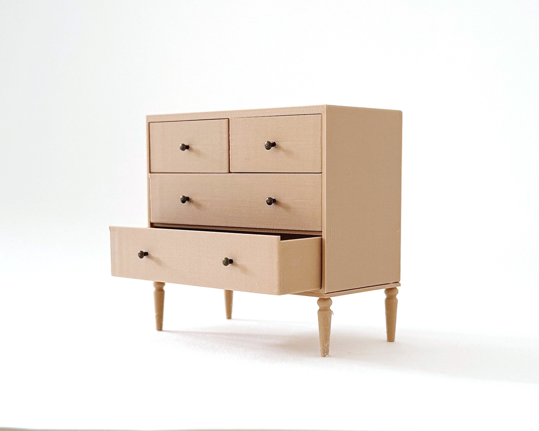 Miniature dollhouse dresser with 4 drawers in natural wood color. Elegant, modern storage featuring intricate tapered legs. Functioning drawers.