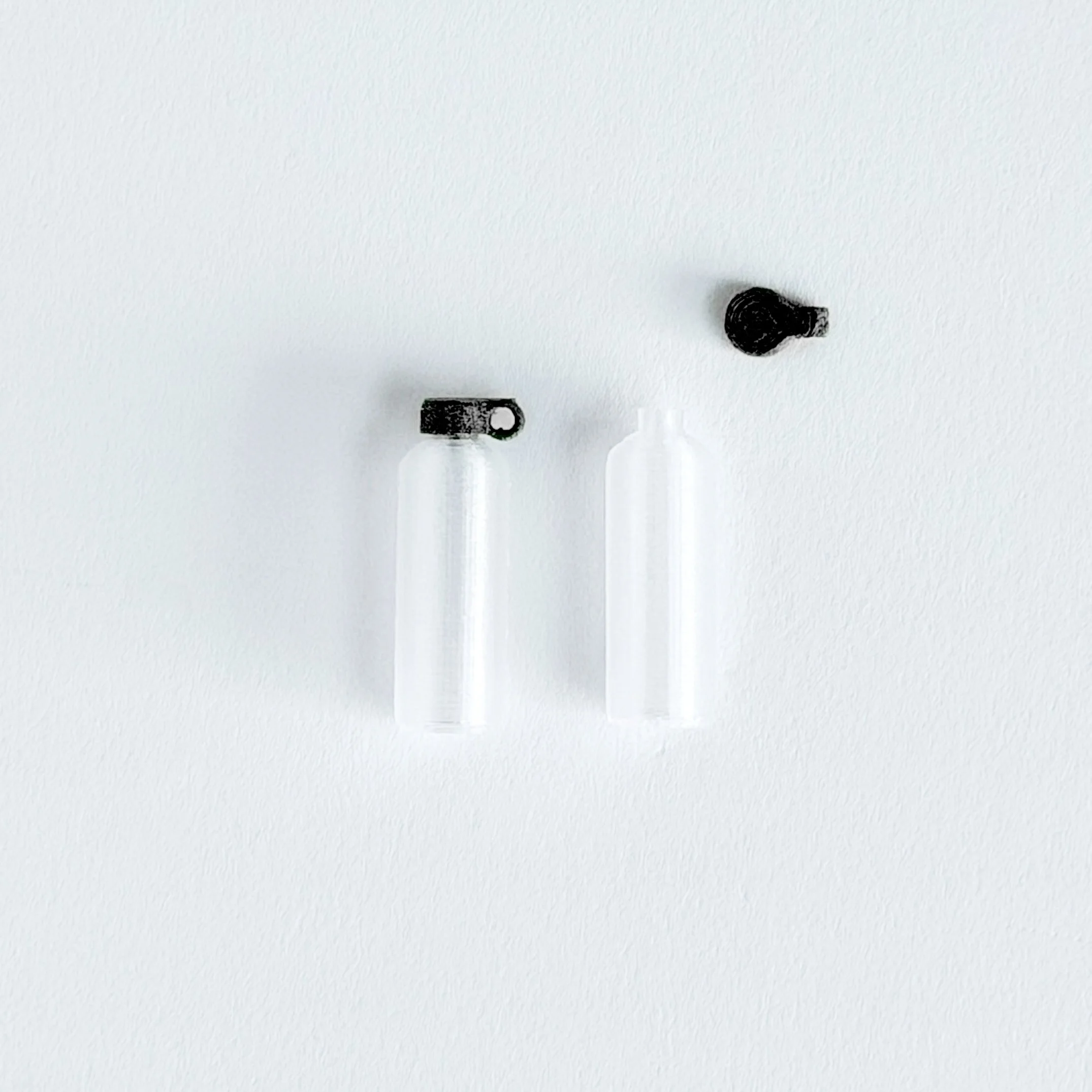1:12 scale miniature black water bottle on bright white background