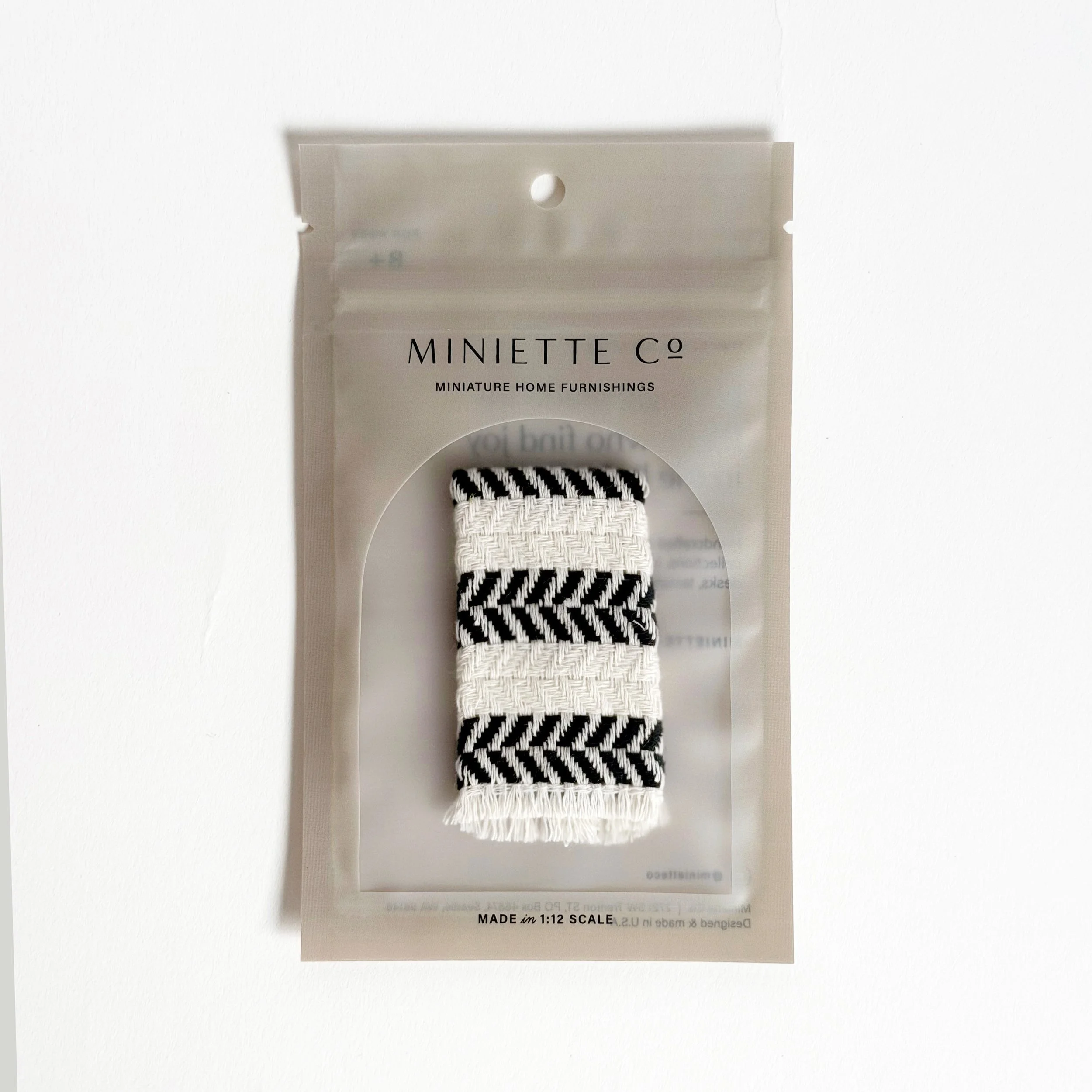 Miniature black beach towel styled for poolside or patio setup