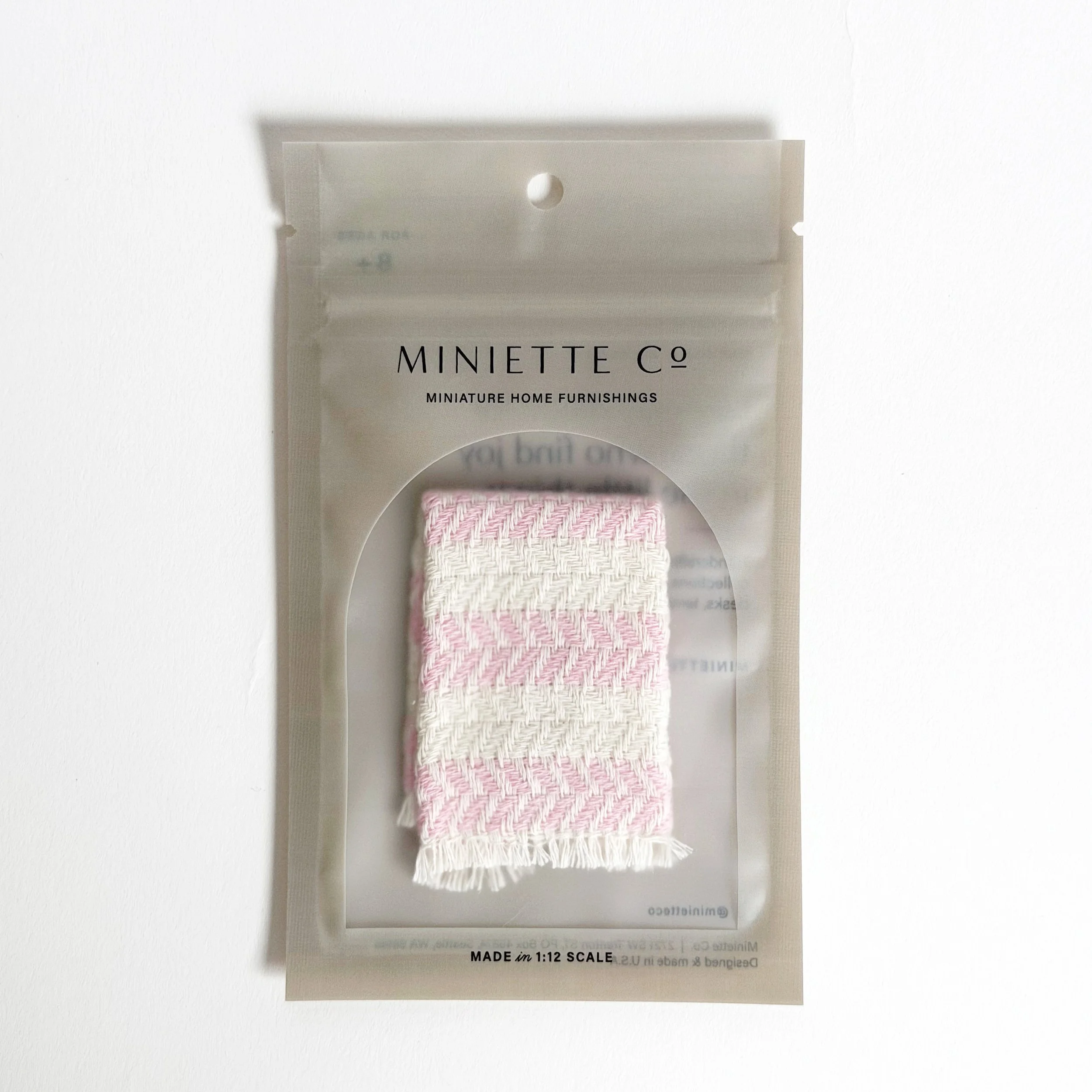 Miniature pink beach towel styled for poolside or patio setup