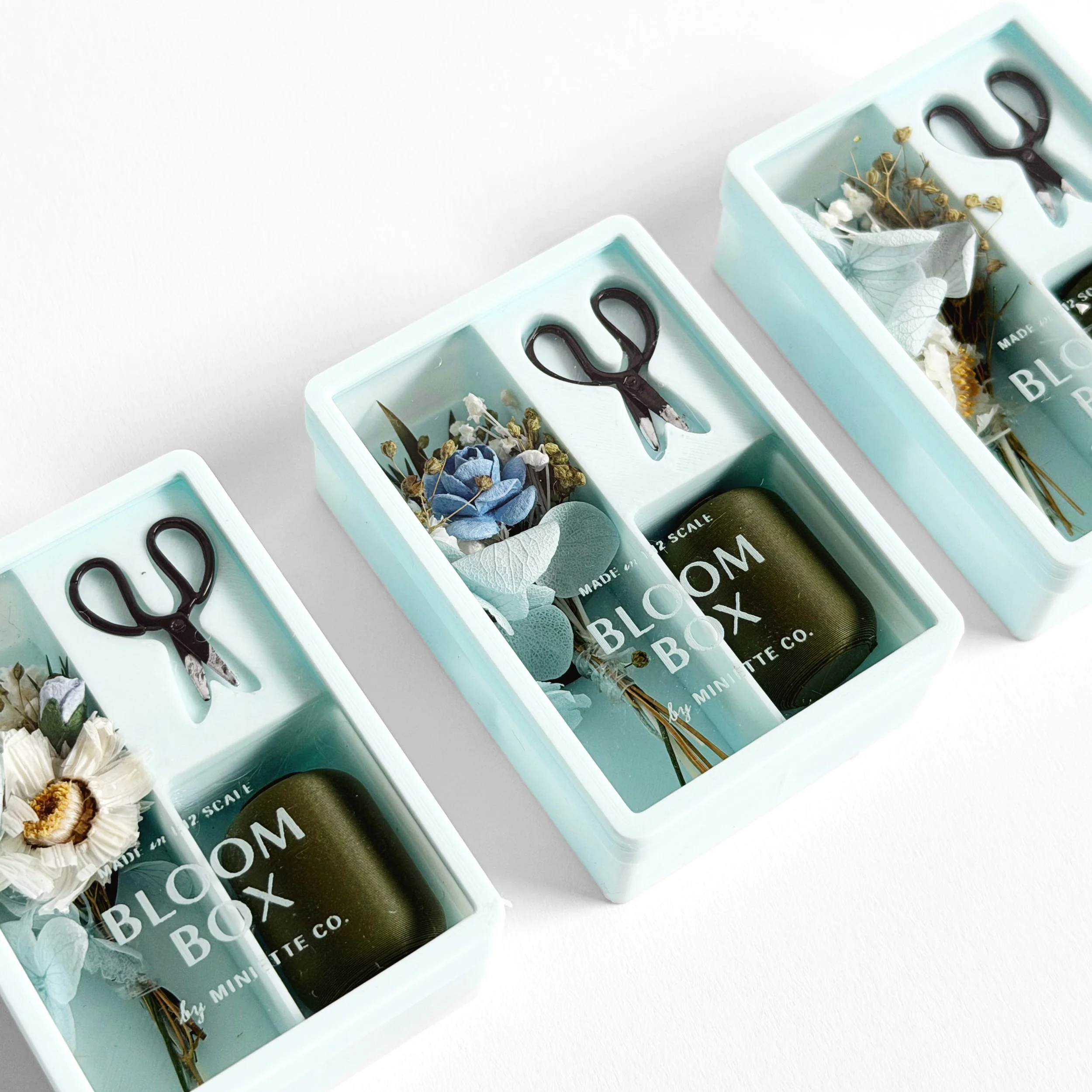 Side view of blue Bloom Box miniature floral gift set in clear display packaging