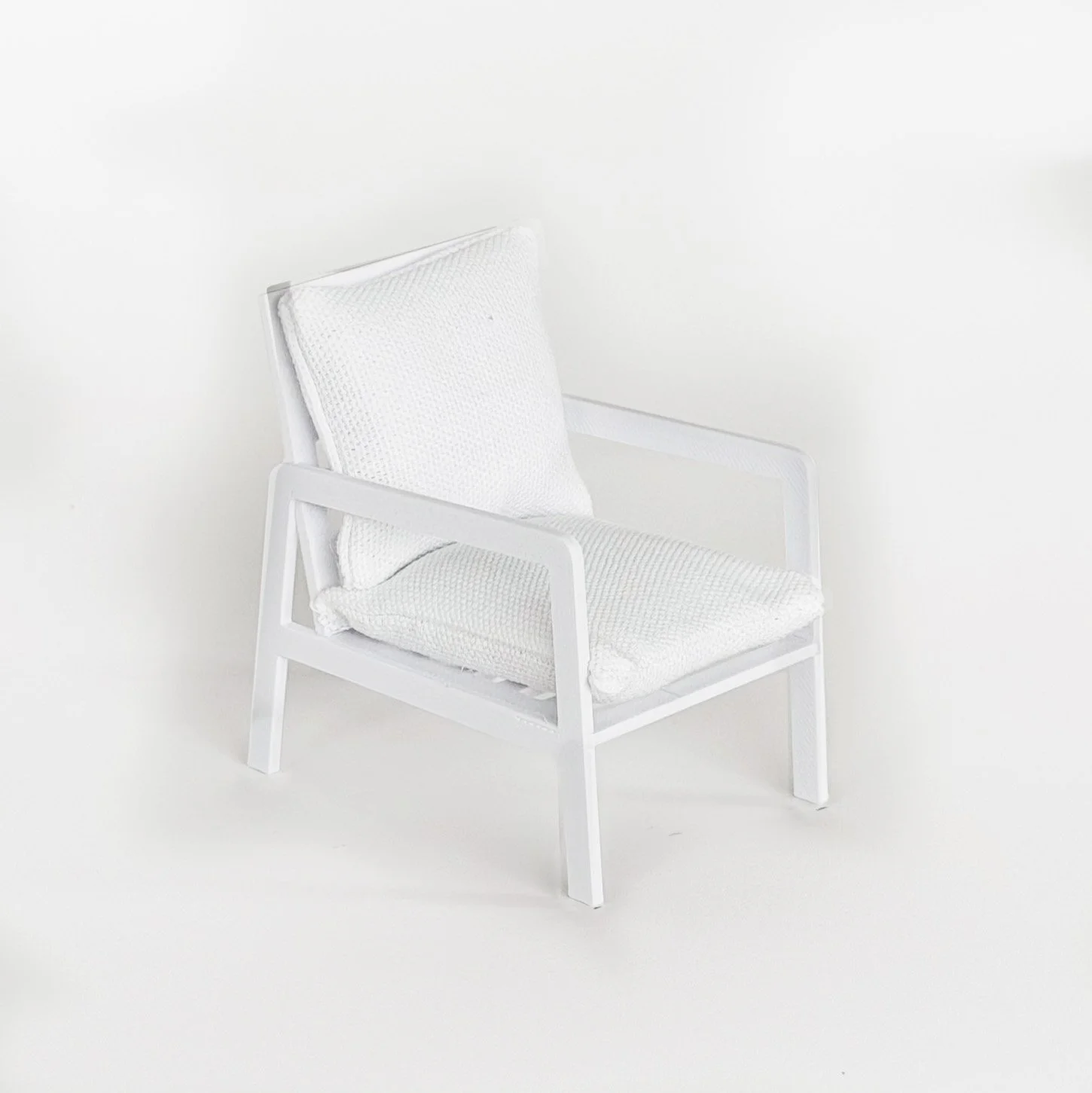 Side view of 1:12 scale modern dollhouse armchair with clean lines and minimalist silhouette