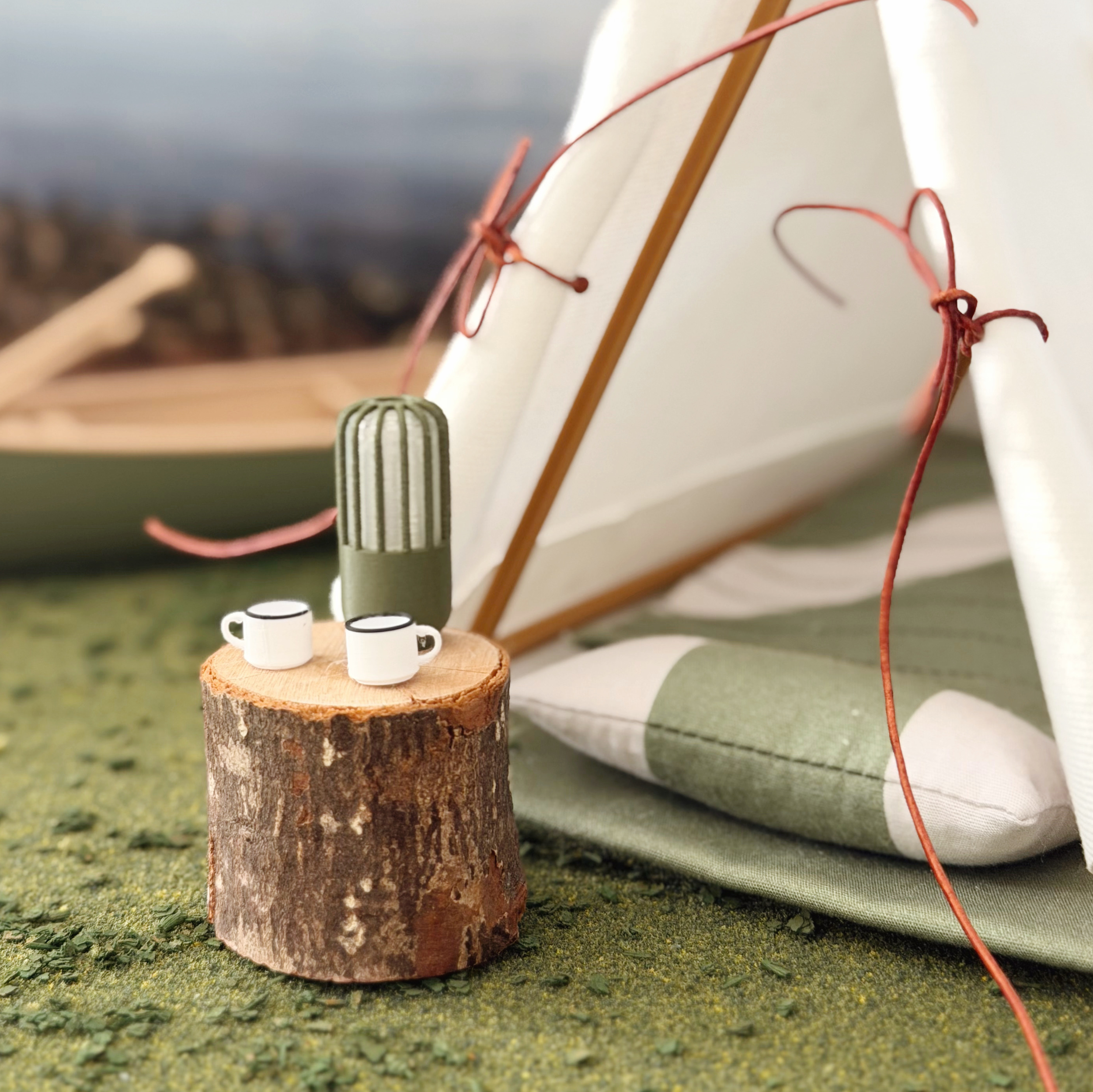 Mini camping lantern styled beside a miniature campfire and camping chair.