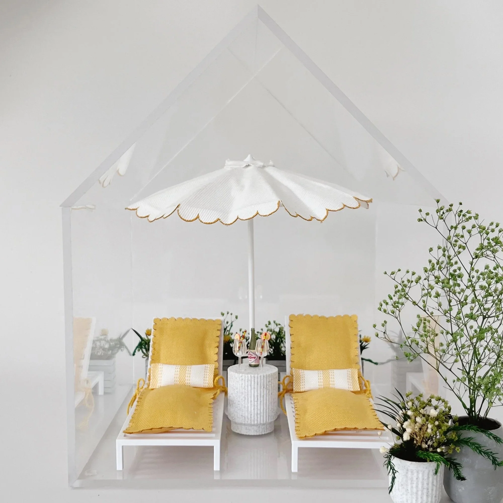 Front view of the Clear Little Loft, a minimalist clear acrylic miniature display with a pitched roof