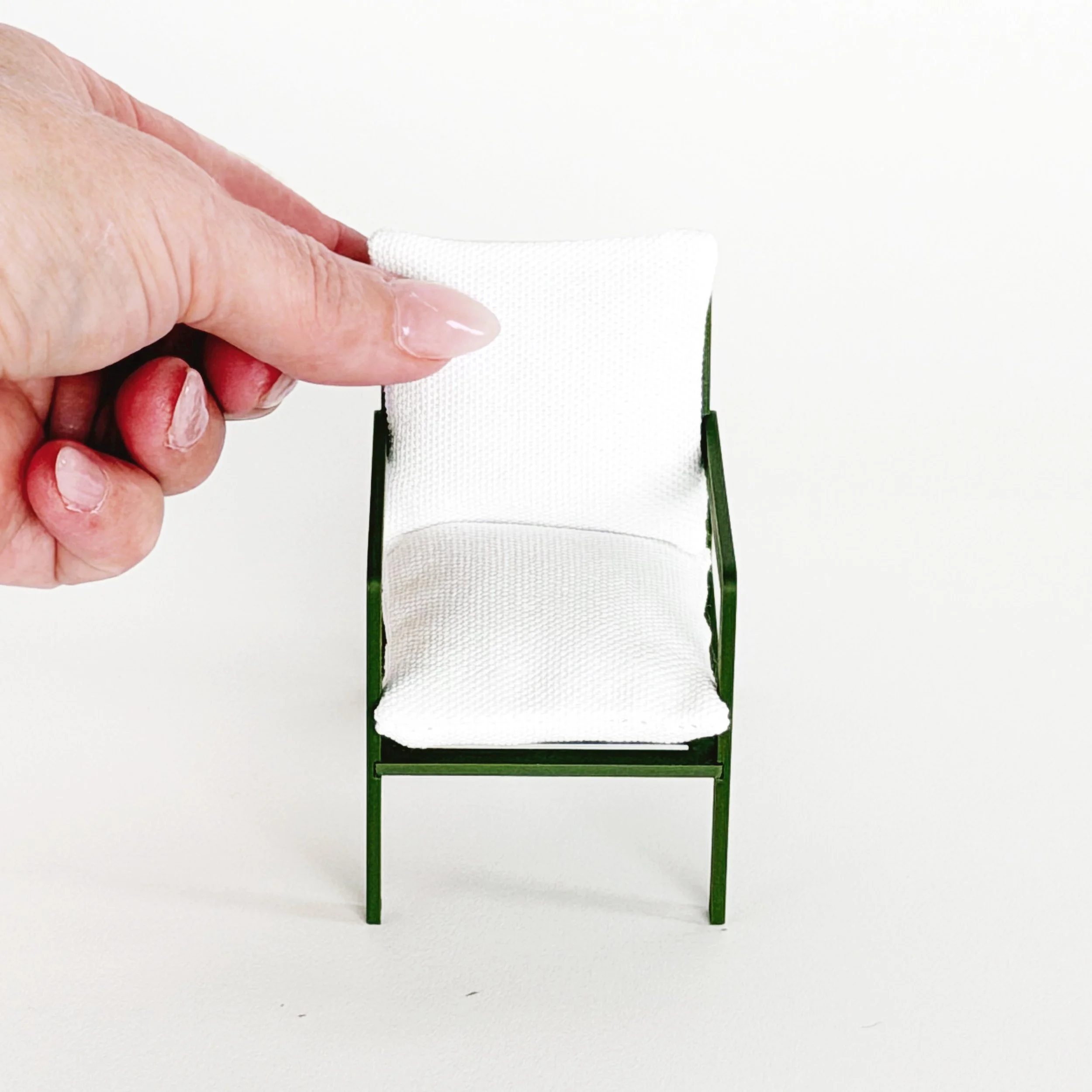 Close-up detail of miniature armchair showing smooth finish and structured design, 1:12 scale dollhouse furniture