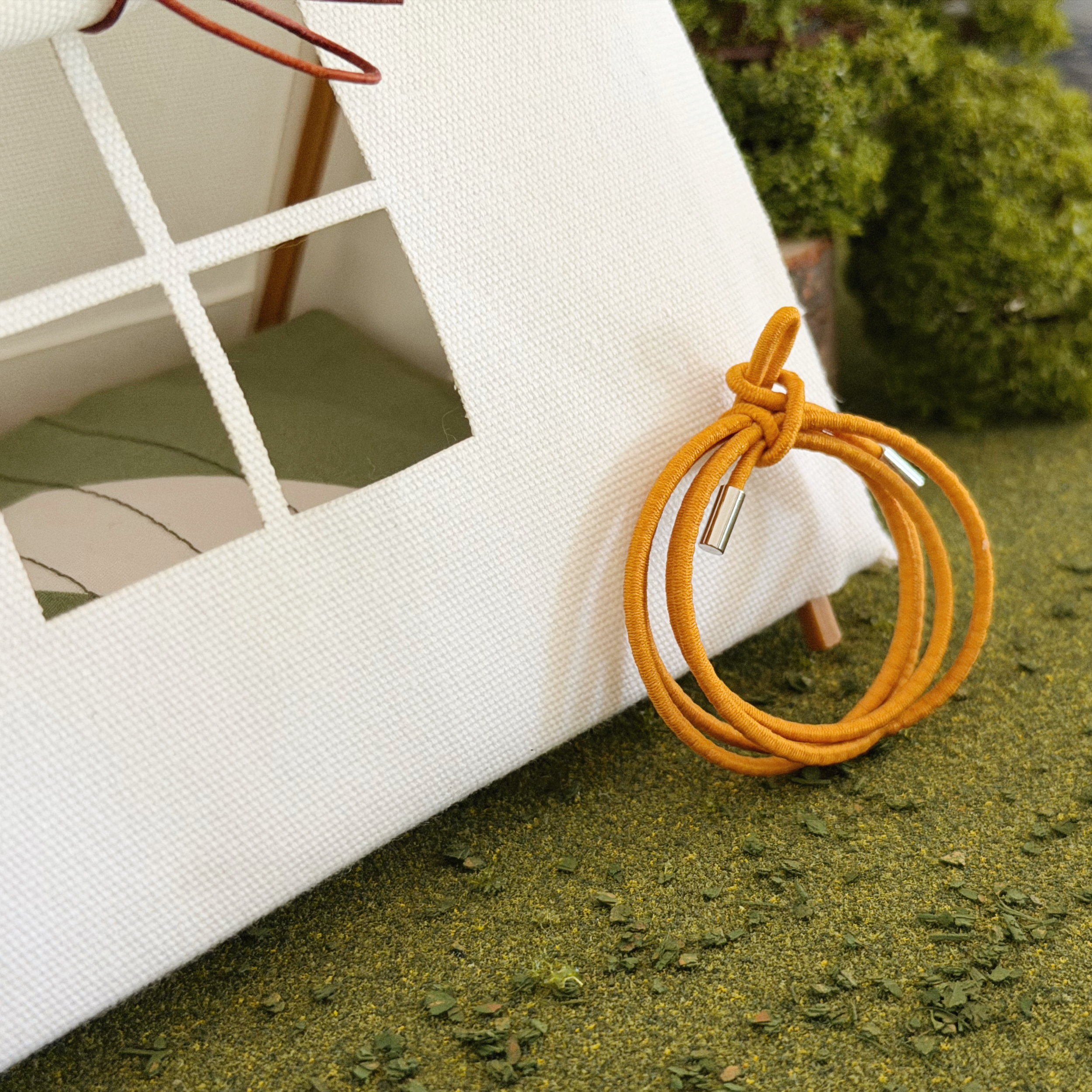 Coiled miniature rope accessory for dollhouse campsites, cabins, and lake houses.