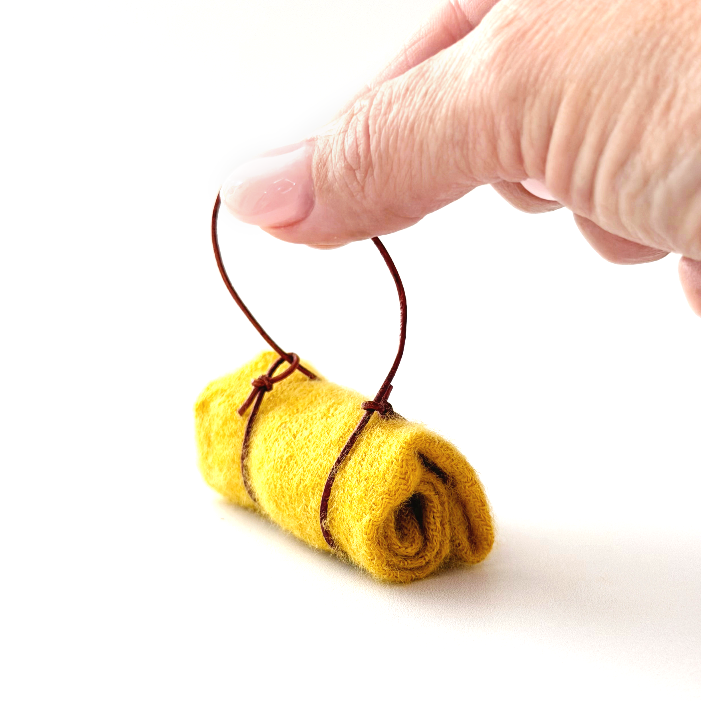 Miniature camping blanket shown next to fingertips for size reference.