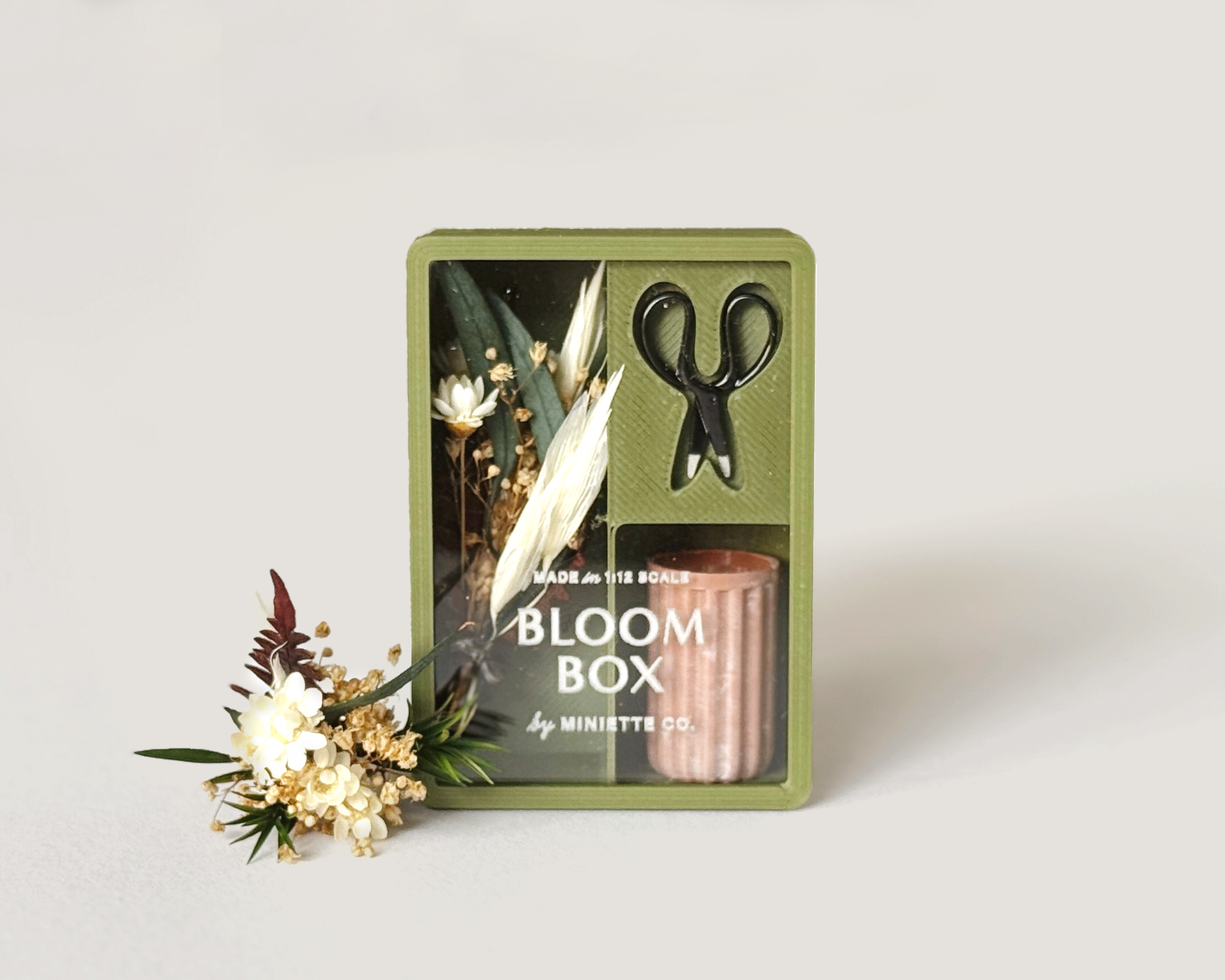 Miniature fall Bloom Box with tiny preserved florals, moss green vase, and working scissors in 1:12 scale.
