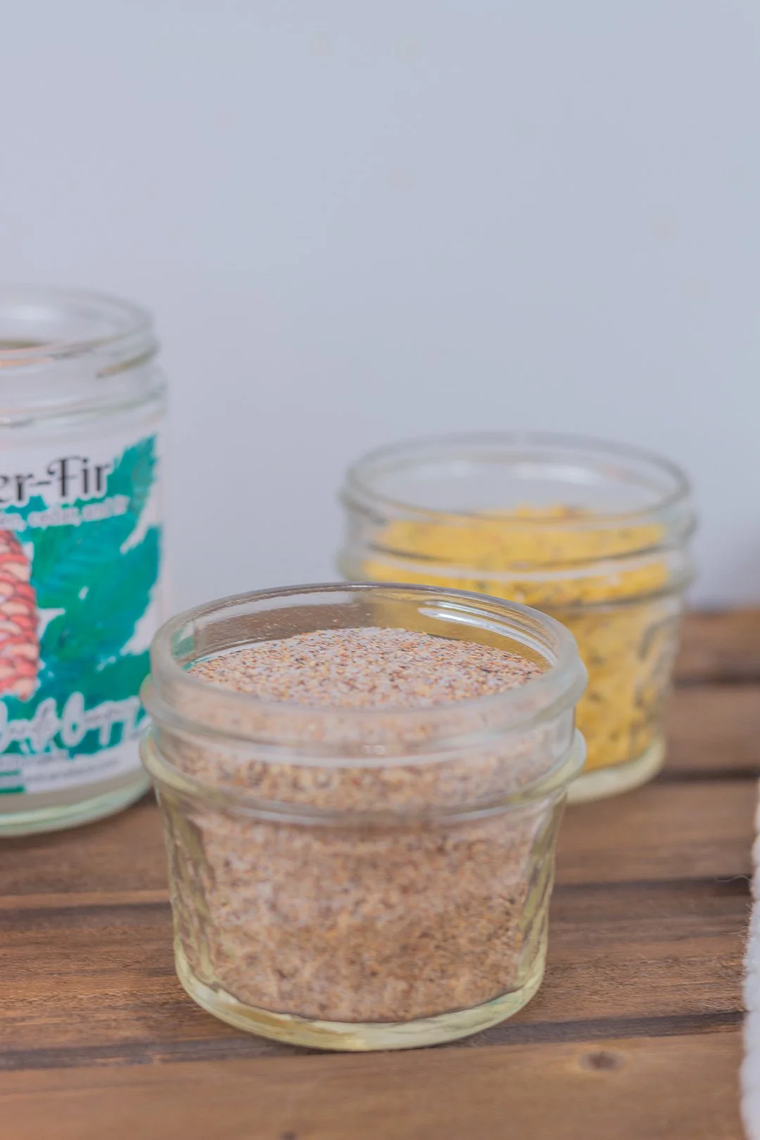 image showing homemade seasoned salt in glass jar with homemade chicken bouillon in background.