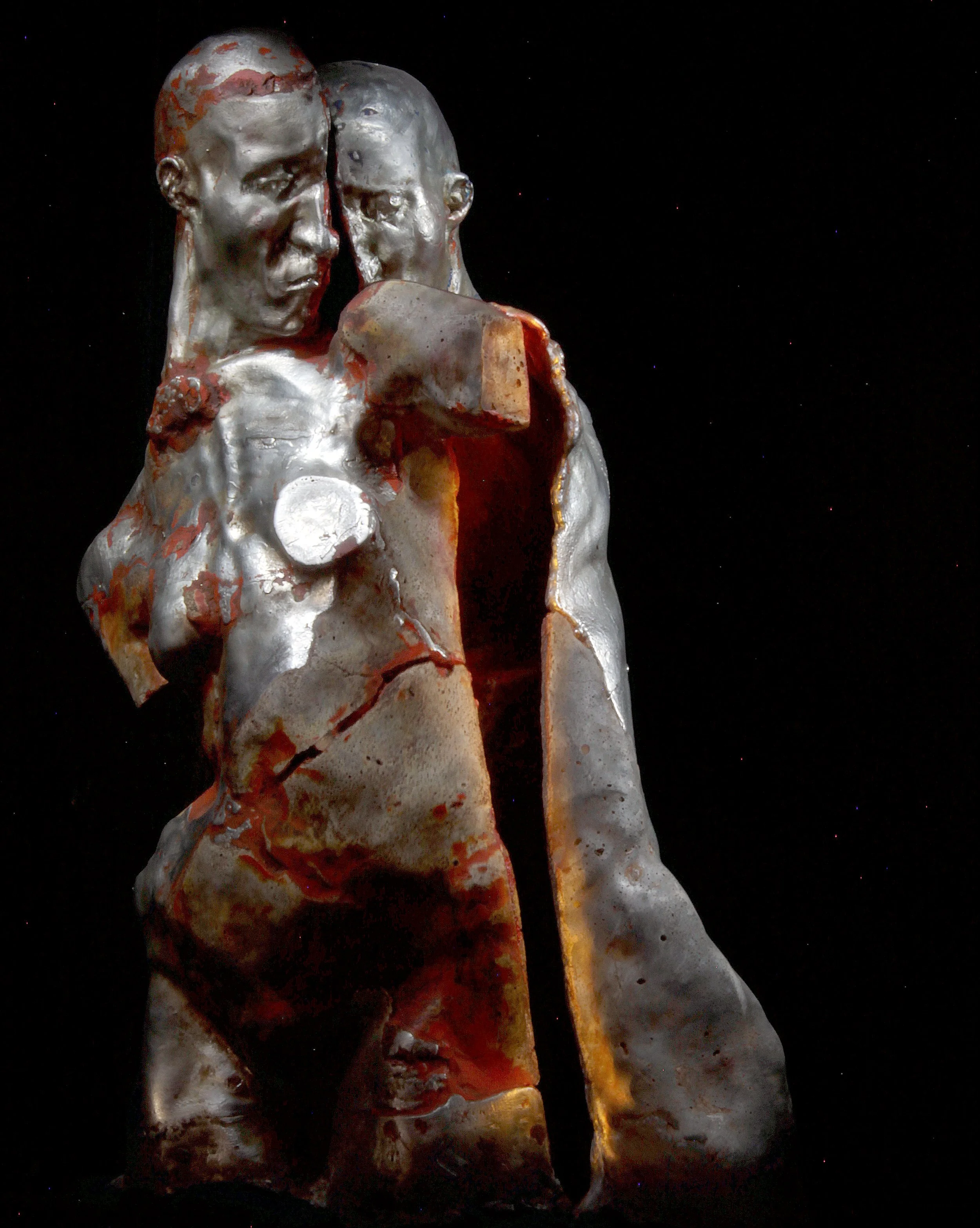 Close-up of a modern sculpture of two faces leaning against each other, with one face having a prominent crack running down the center, set against a dark background.