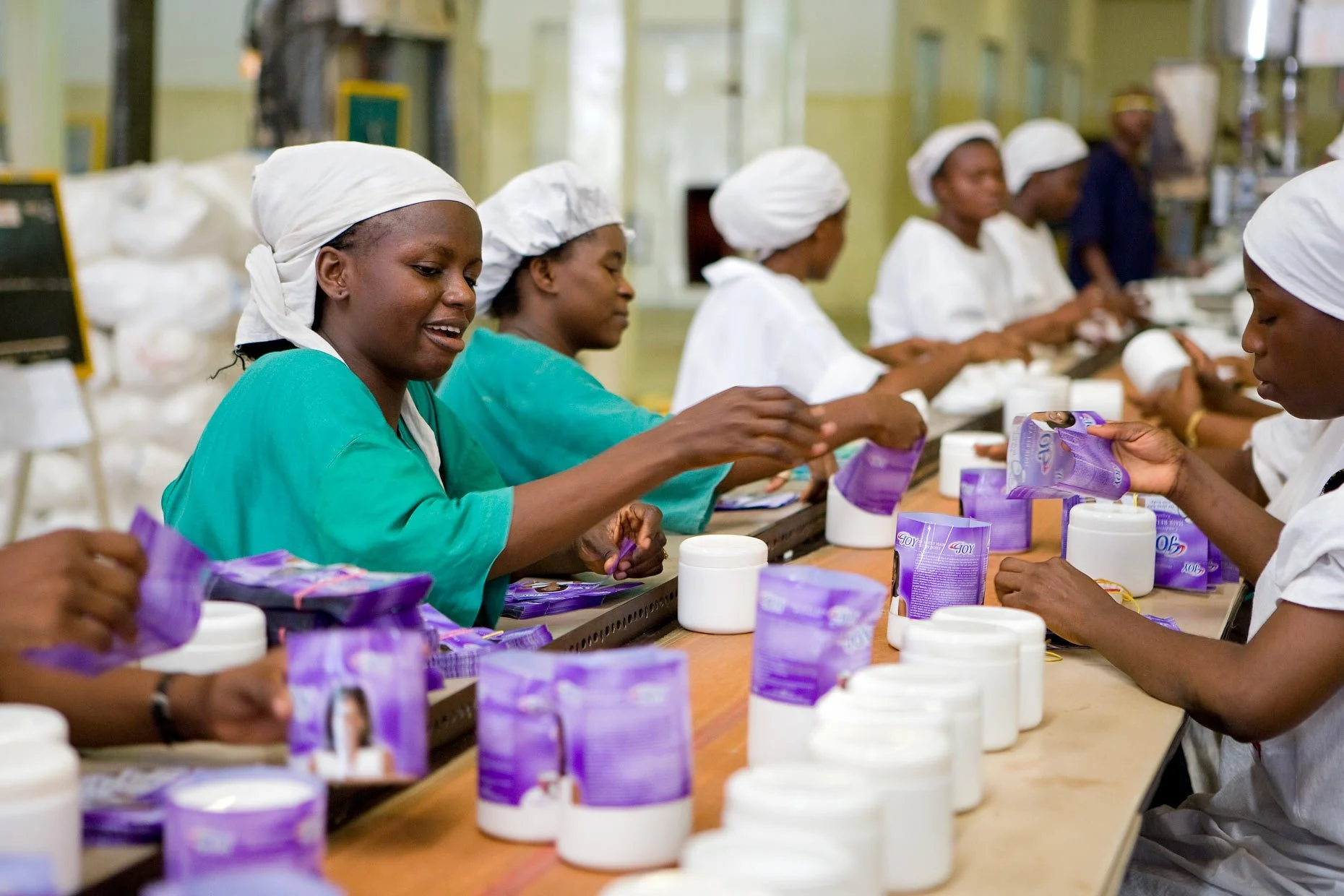 African women working together on a factory assembly line, highlighting skilled labor and teamwork in a manufacturing environment.