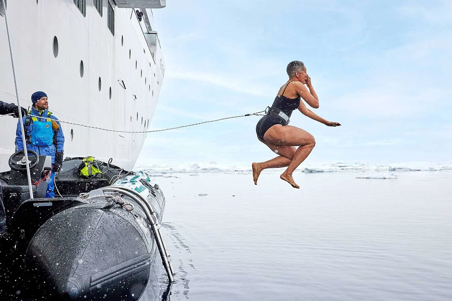 Luxury travel photography woman jumping Antarctic waters Silversea cruise campaign