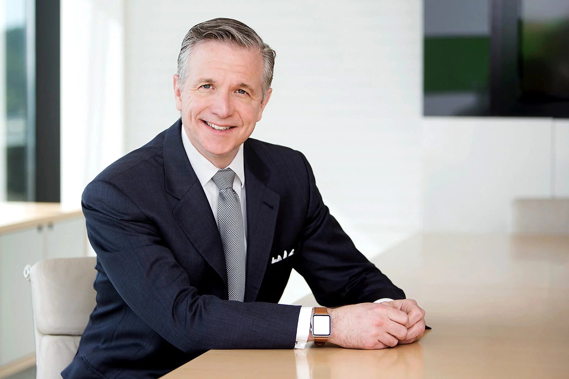 Portrait of a chief executive in a minimalist office setting, conveying leadership, professionalism, and modern corporate style.