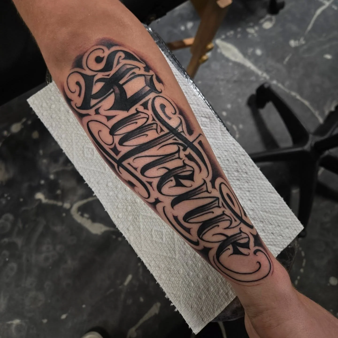 "Patience" across the forearm. Script lettering style with a calligraphy style capital letter. I love doing stuff in this style, dm me or email me at Aaron@diaztattoos.com to book your next tattoo. 
I have a last minute opening tomorrow aft
