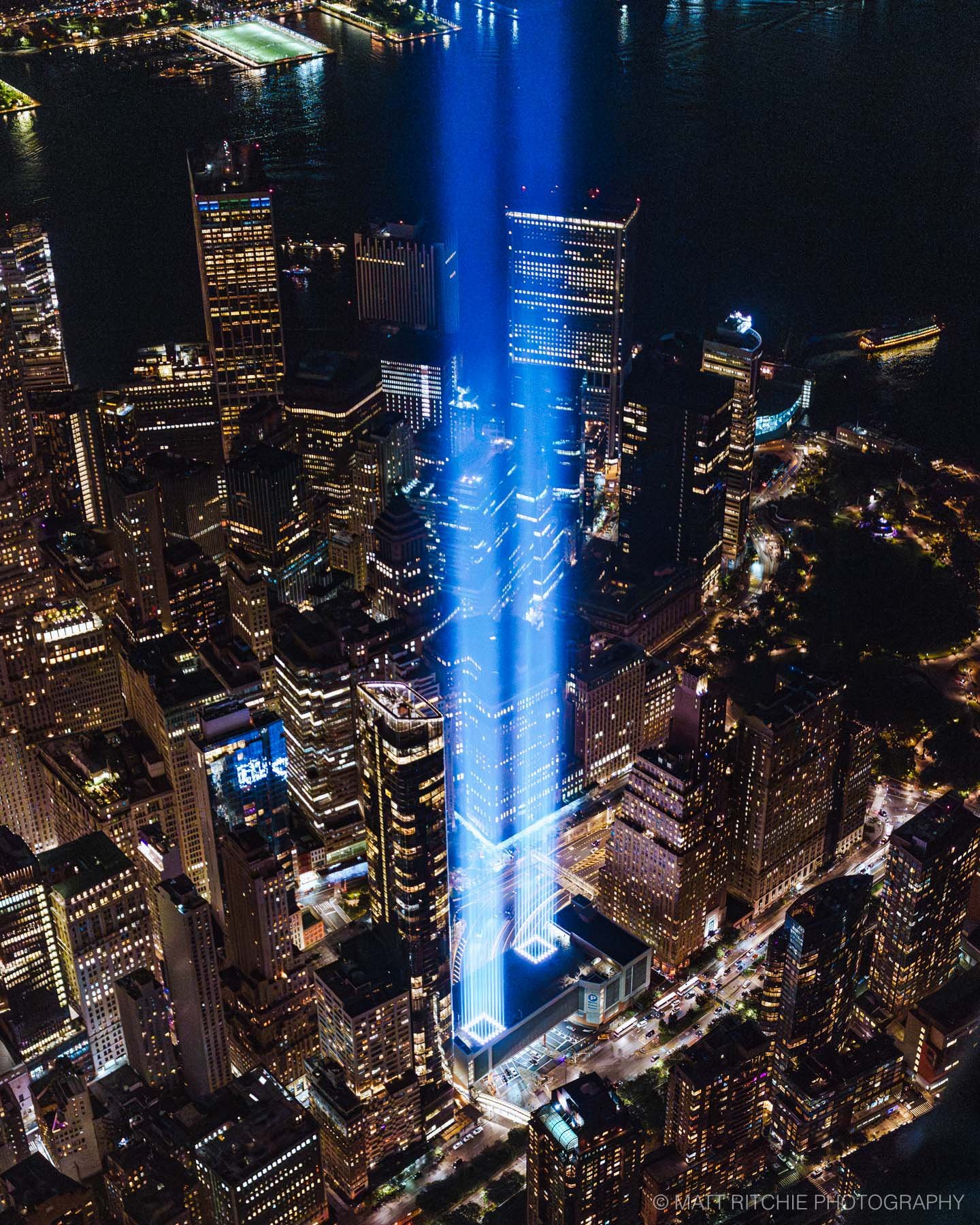 Tribute in Light memorial rising above Lower Manhattan at night, seen from a FlyNYON helicopter over New York City.