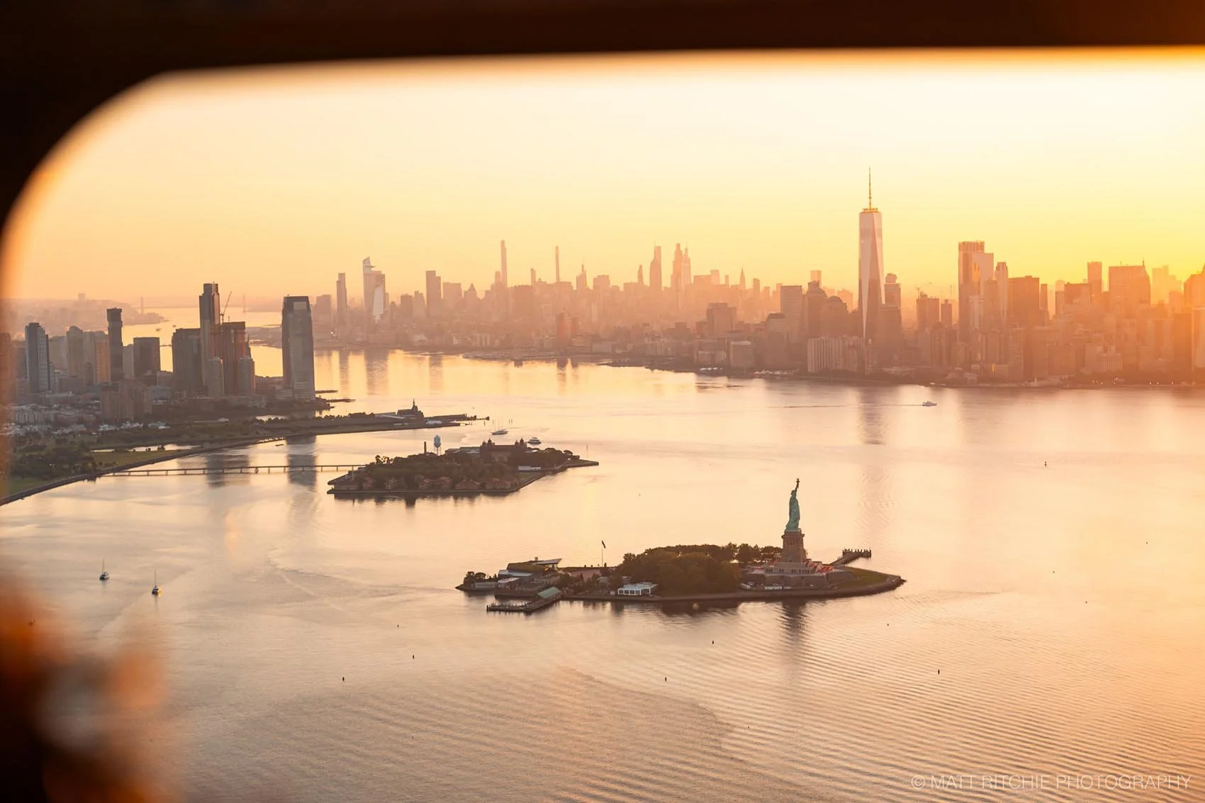 Statue of Liberty photographed from above during an NYC helicopter flight at sunrise