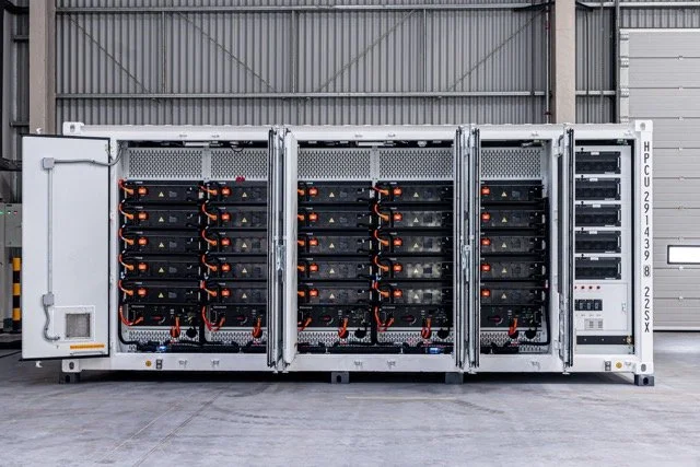 Kraftig data- eller server-reaktorkabinett med mange servere og kabler, plassert i et industrilager.