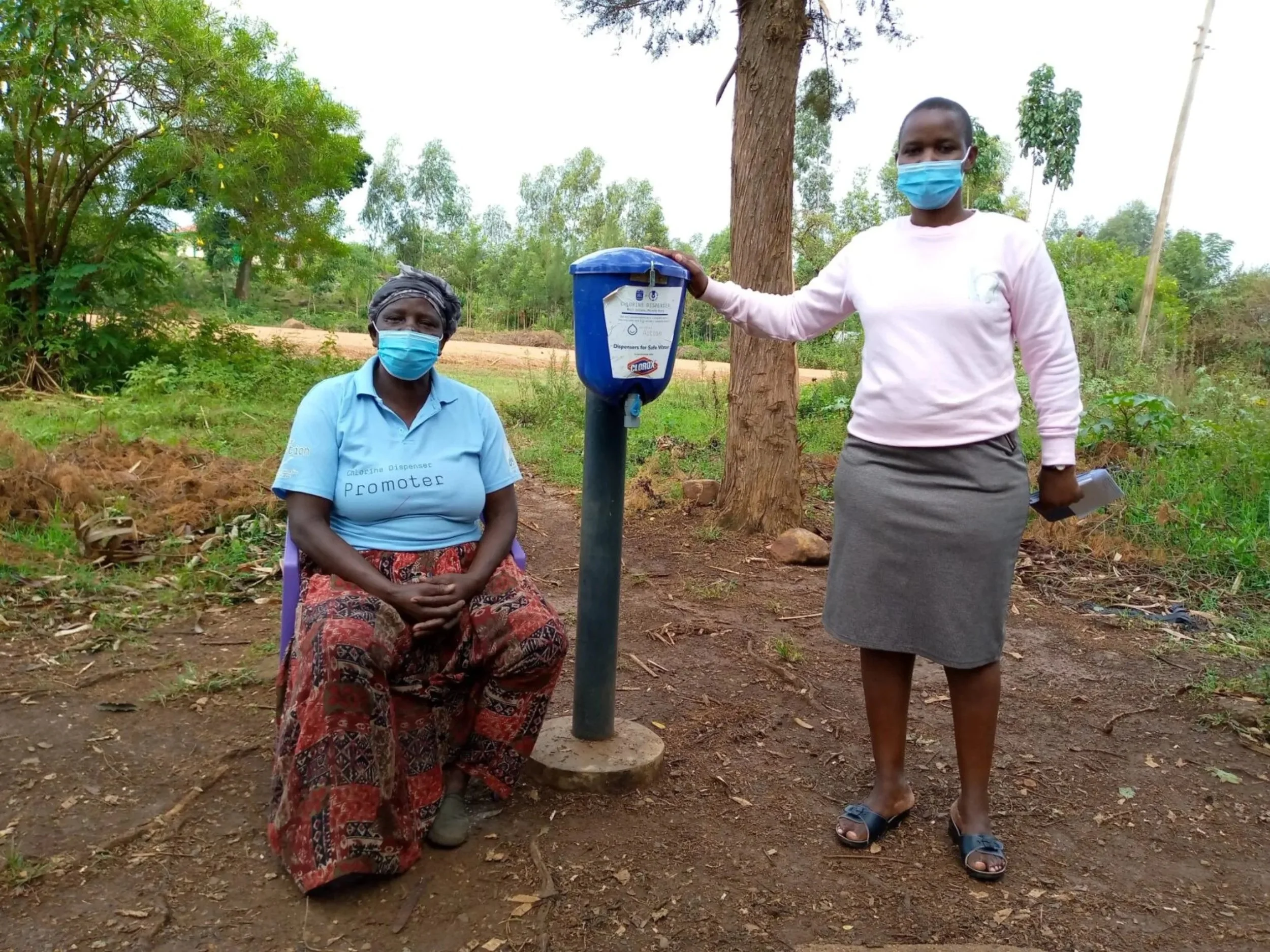 Promoter Rose Okong’o with Lead Officer Ruth Sabai by a chlorine dispenser in Migori County, Kenya..jpeg
