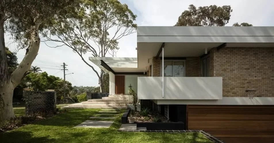 A reworked 1960s modern home retains its original structure while removing a series of later additions, restoring clarity to the form and intent of the design.

A horizontal roof plane extends to define the entry, supported by a steel beam and lightw