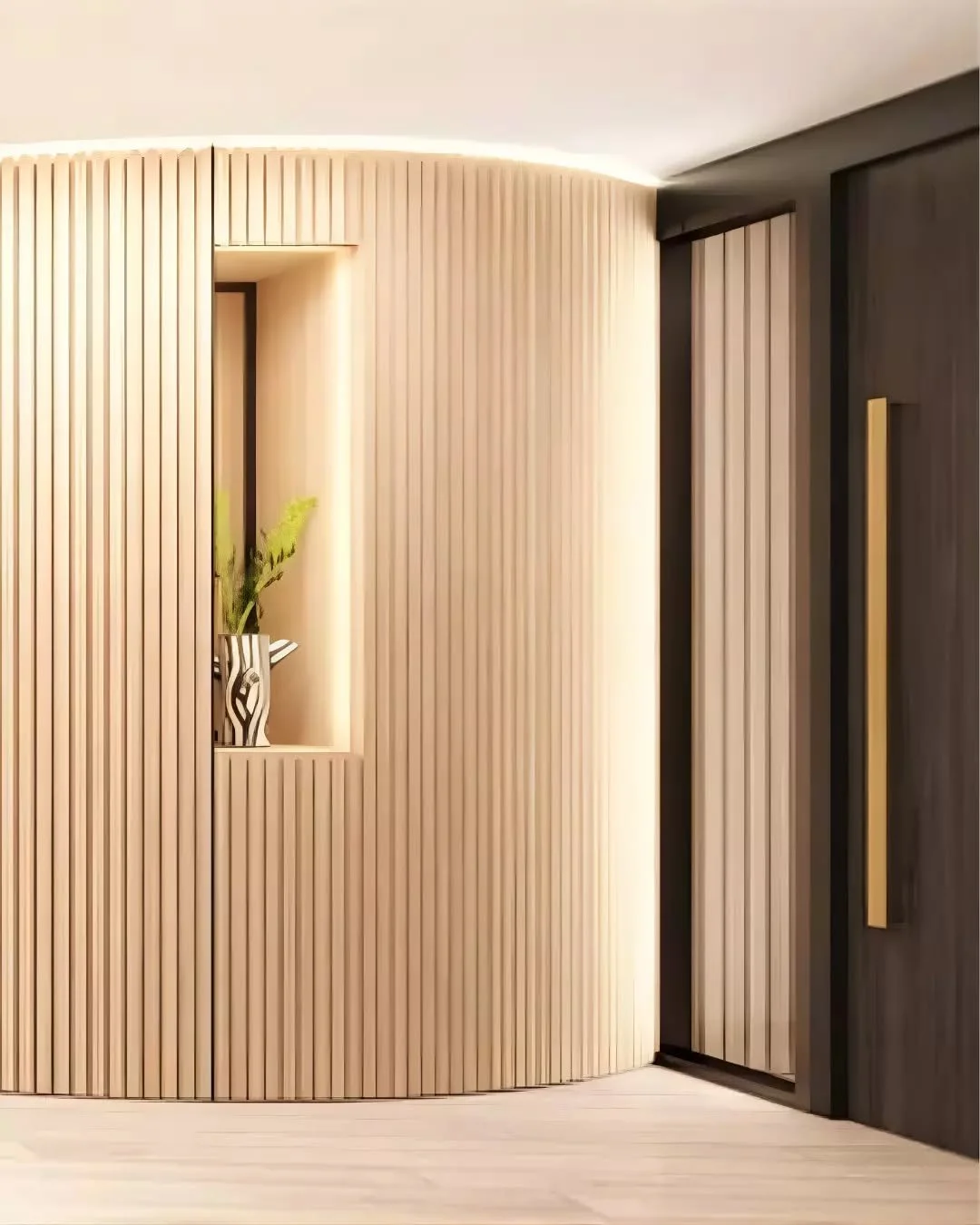 A curved wall lined with vertical timber battens defines the entry, introducing texture and rhythm to the space. The form wraps gently to create a recessed niche, where lighting highlights the depth of the wall and frames a moment of display.

Adjace
