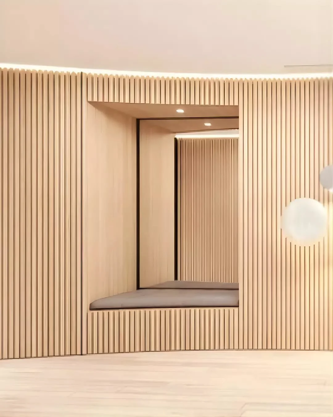 A recessed opening is integrated within the timber-lined wall, forming a framed threshold that draws the eye inward. As part of a corridor that weaves through the entry and into the home, the wall serves multiple functions&mdash;concealing storage an