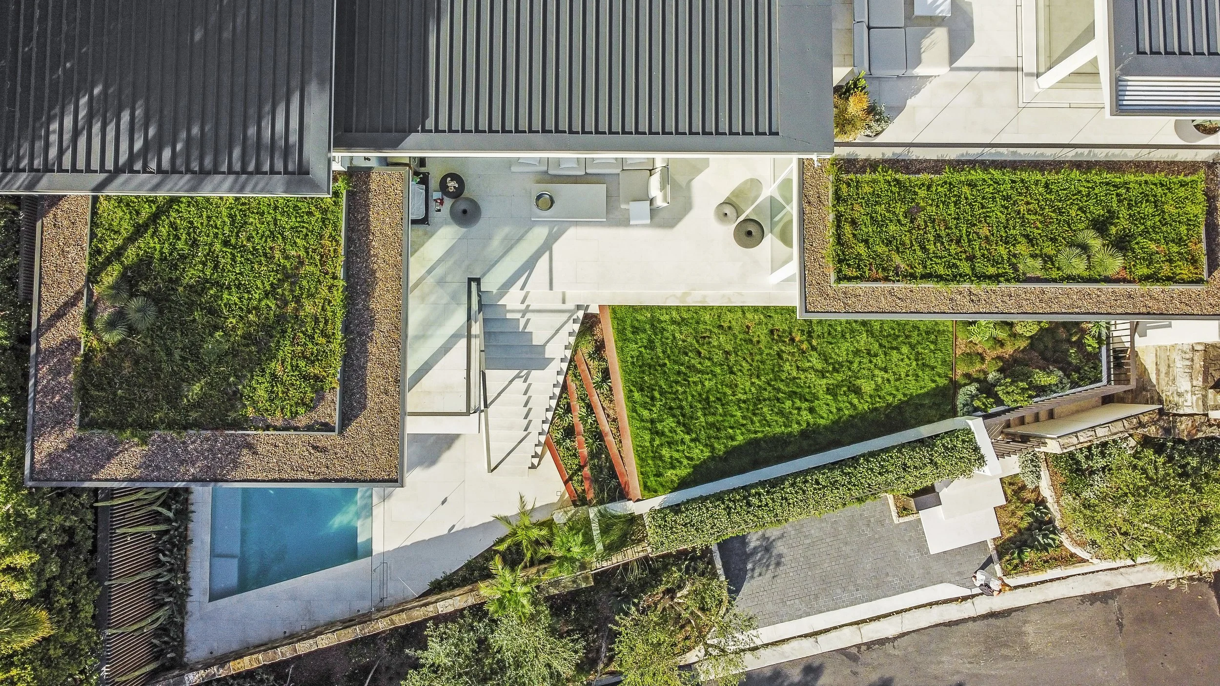 Aerial view of a contemporary residential property featuring a swimming pool, landscaped terraced garden, north outdoor living and enteratining areas