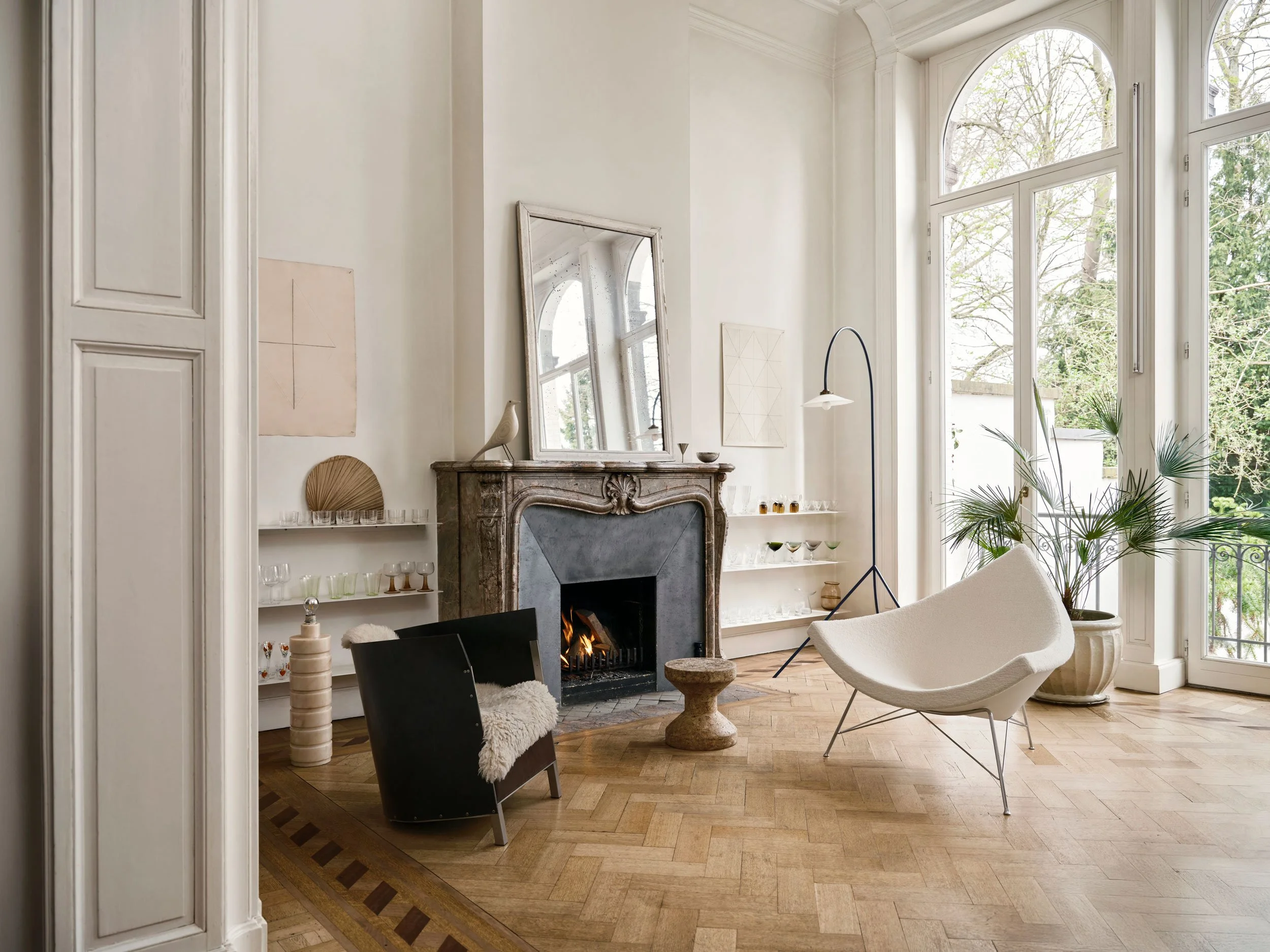 Home Stories for Winter 25 wurden beim Architekten David Van Severen und der Modefotografin Martina Bjorn fotografiert. Coconut Chair in creme mit Cork Stool vor Cheminée.