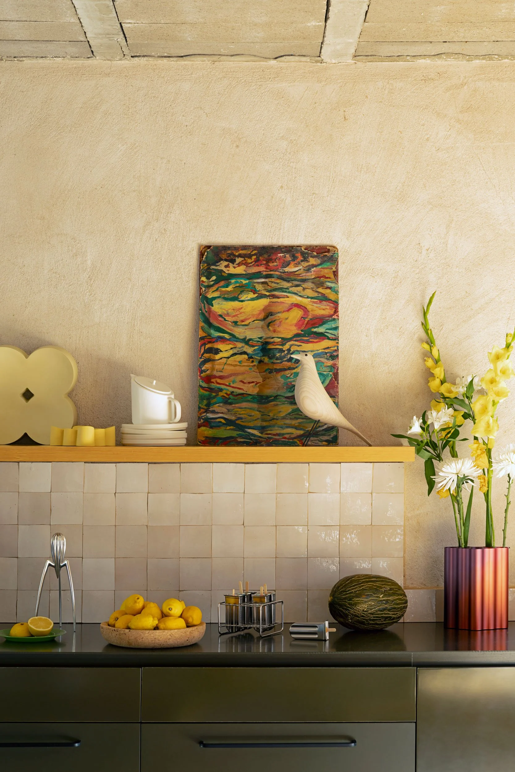 weisser Eames House Bird steht in der Küche auf einem Tablar. Nuage mit Blumen steht auf der Küchenablage