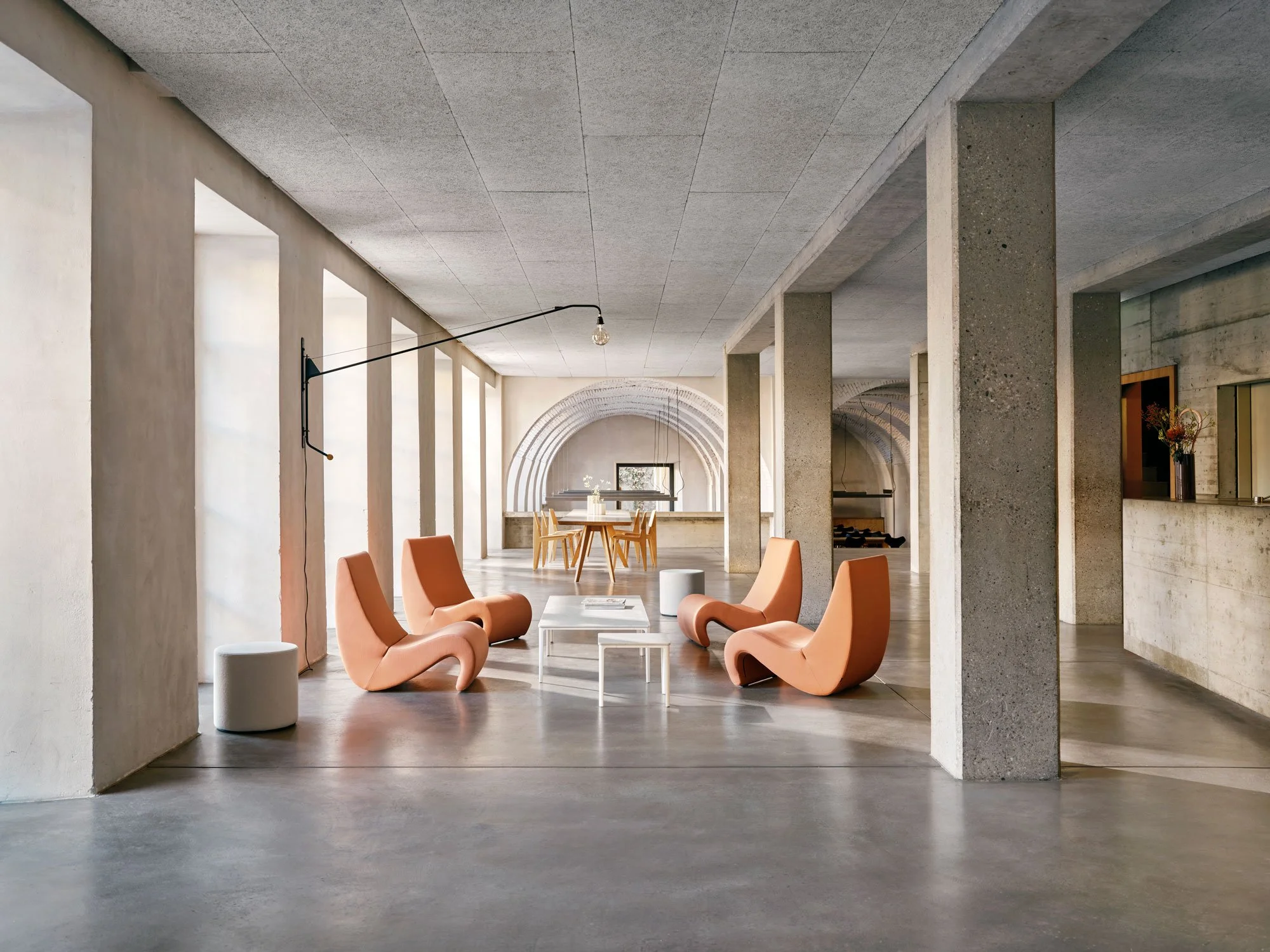 Jugendherberge Basel, Eingangsbereich mit Panton Sesseln (Amoebe) und einem Marmor Couchtisch. An der Wand hängt eine Potence Leuchte. Im Hintergrund steht ein Tisch mit Prouve Holz Stühlen 