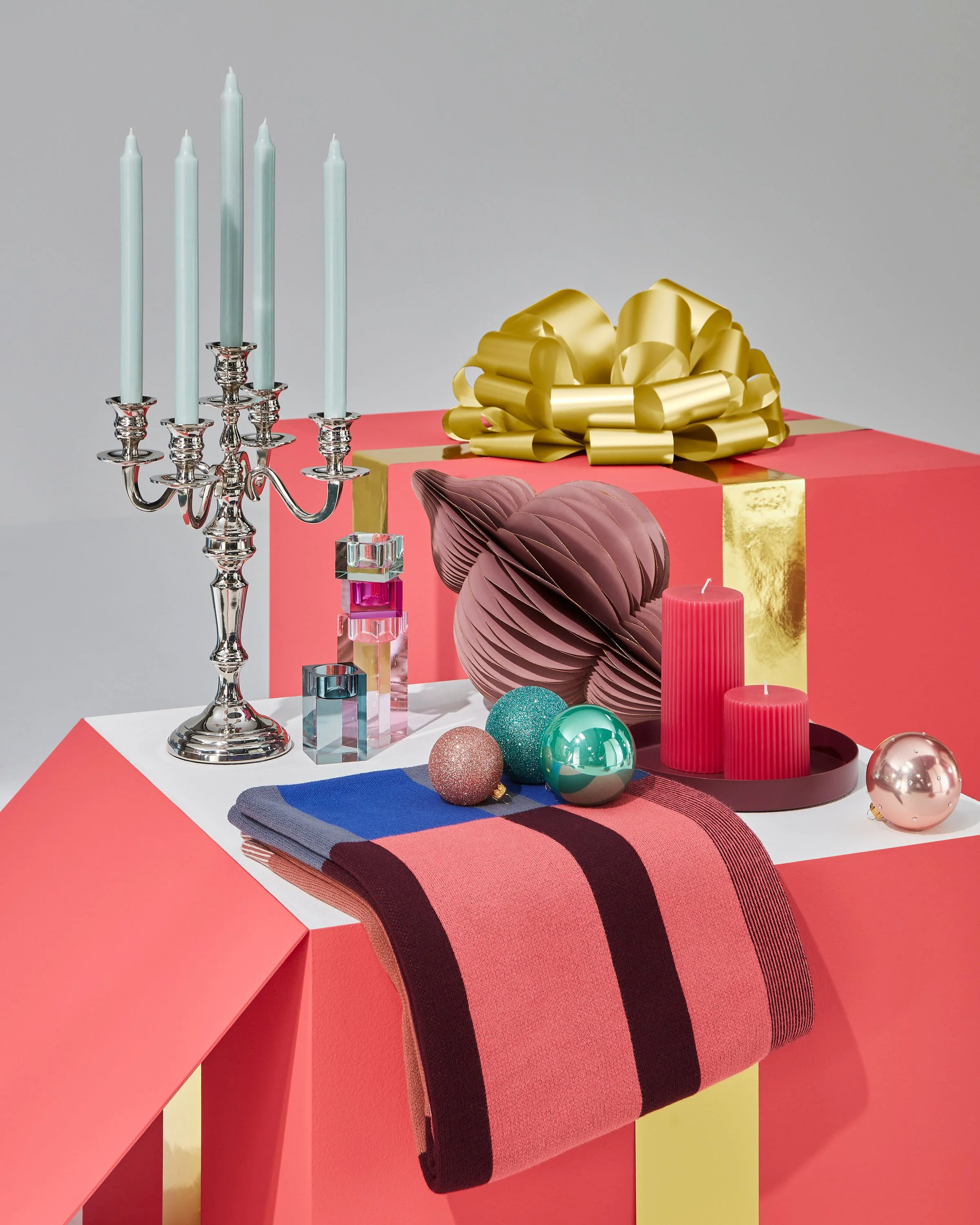 Ein Spiel von skalierten, übergrossen Paketen bildet die Basis des Konzepts. Fliegende Geschenke verleihen dem Aufritt eine Dynamik, sinnbildlich für das Auspacken der Geschenke.  Magenta Pakete mit goldener Schlaufe und Geschenkideen