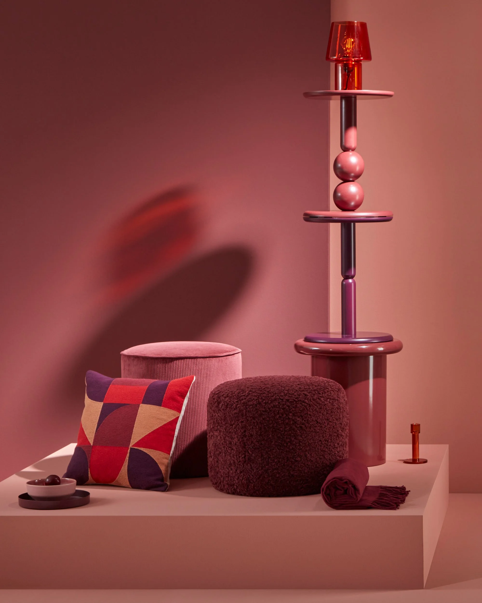 Die jeweiligen Trendthemen wurden in einer abstrakten Darstellung auf einem Podium präsentiert, gestapelt, gehängt. Ein passender Hintergrund in Farbe oder Material reagierte auf das jeweilige Produkt. Thema Bordeaux: Produkte in rot und Bordeaux Tön