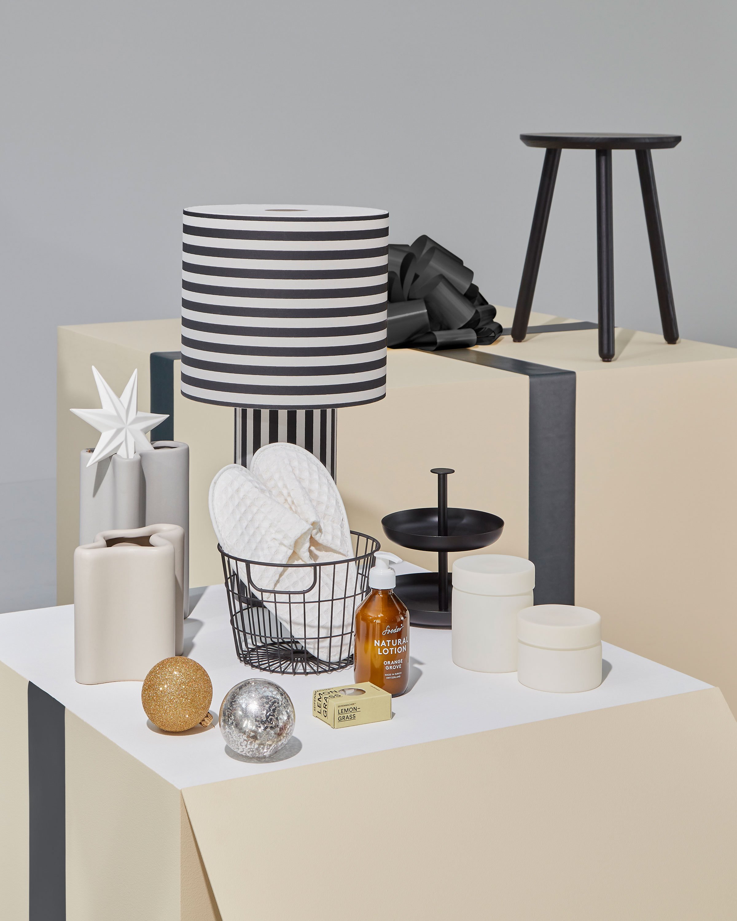 Ein Spiel von skalierten, übergrossen Paketen bildet die Basis des Konzepts. Fliegende Geschenke verleihen dem Aufritt eine Dynamik, sinnbildlich für das Auspacken der Geschenke.  Pakete in creme mit anthrazit Schlaufe und Geschenkideen